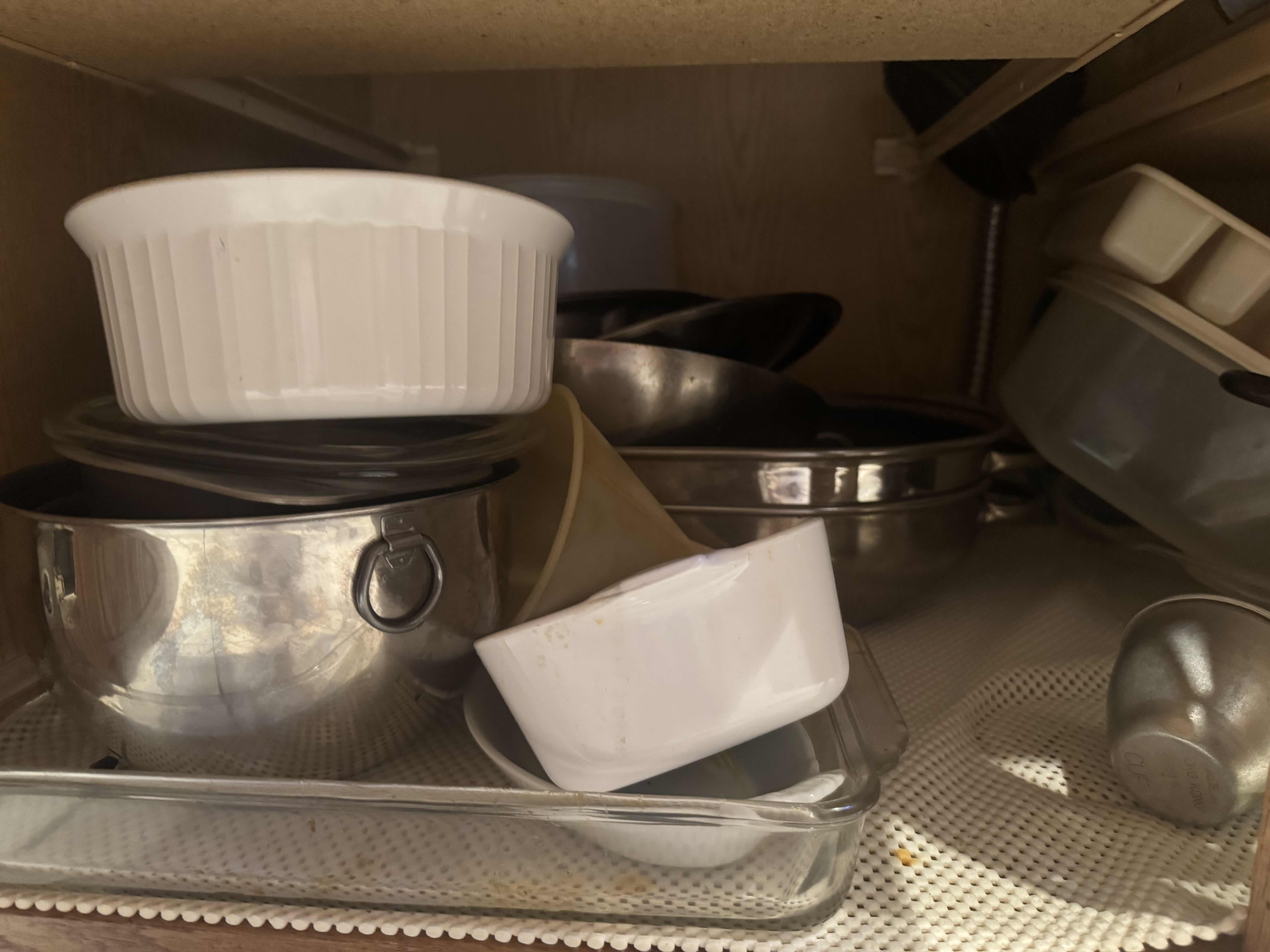 Photo 1 of CONTENTS OF KITCHEN CABINET. MIXING AND SERVING BOWLS AND DISHES. POTS AND PANS, AND BAKING DISHES.