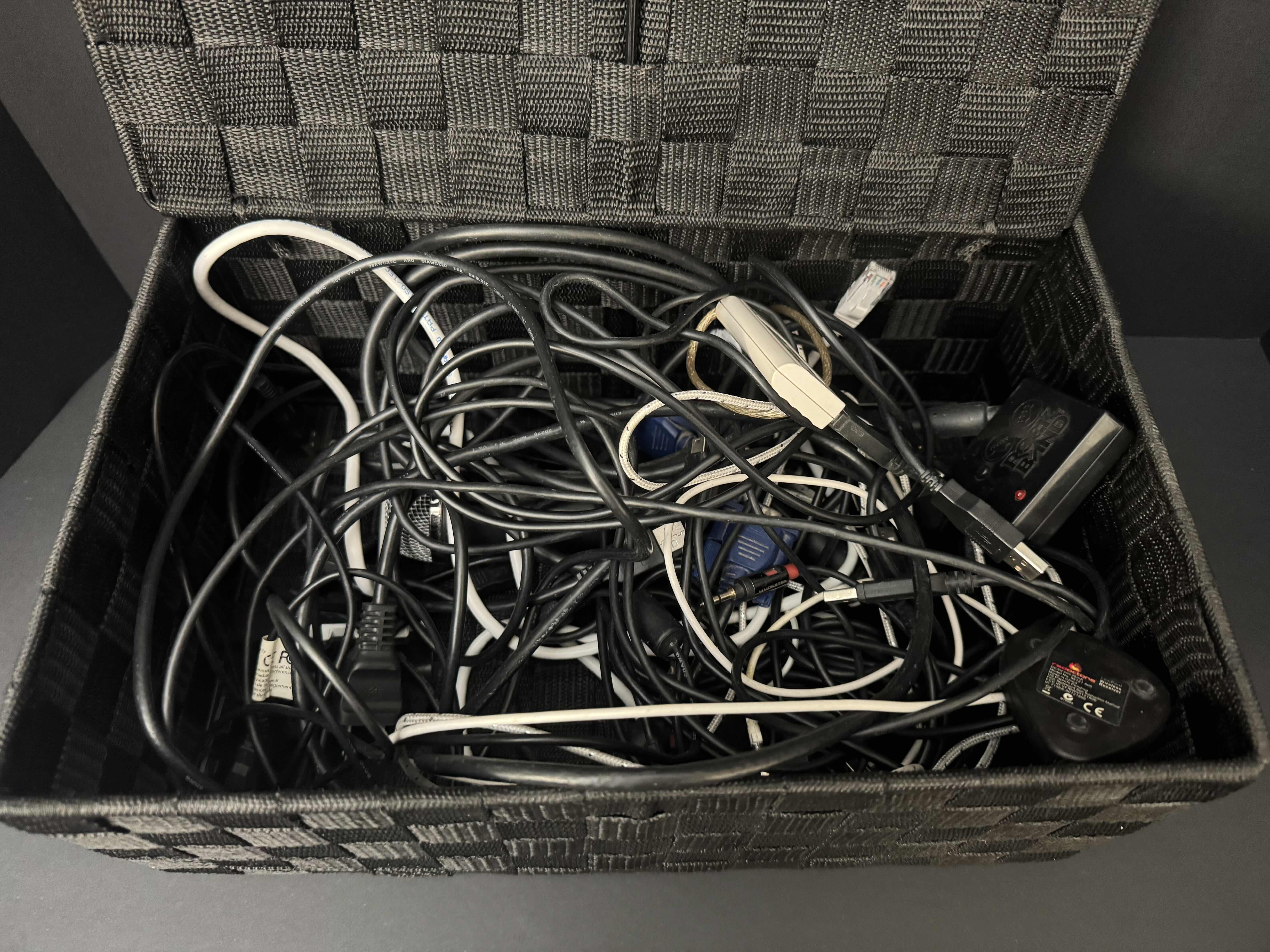 Photo 1 of BLACK WOVEN BASKET FILLED WITH ELECTRONIC CORDS AND LARGE TV LEGS, 2 PORTABLE PHONE CHARGERS & AMAZON TV HUB
