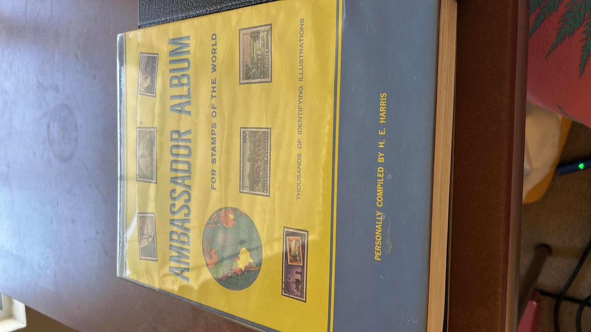 Photo 1 of “POSTAGE STAMPS OF THE UNITED STATES” ALBUM (NO CONTENT) AND “AMBASSADOR’S FOR STAMPS OF THE WORLD” SEVERAL PAGES OF MINT AND CANCELLED FOREIGN STAMPS STAMPS - NO RETURNS