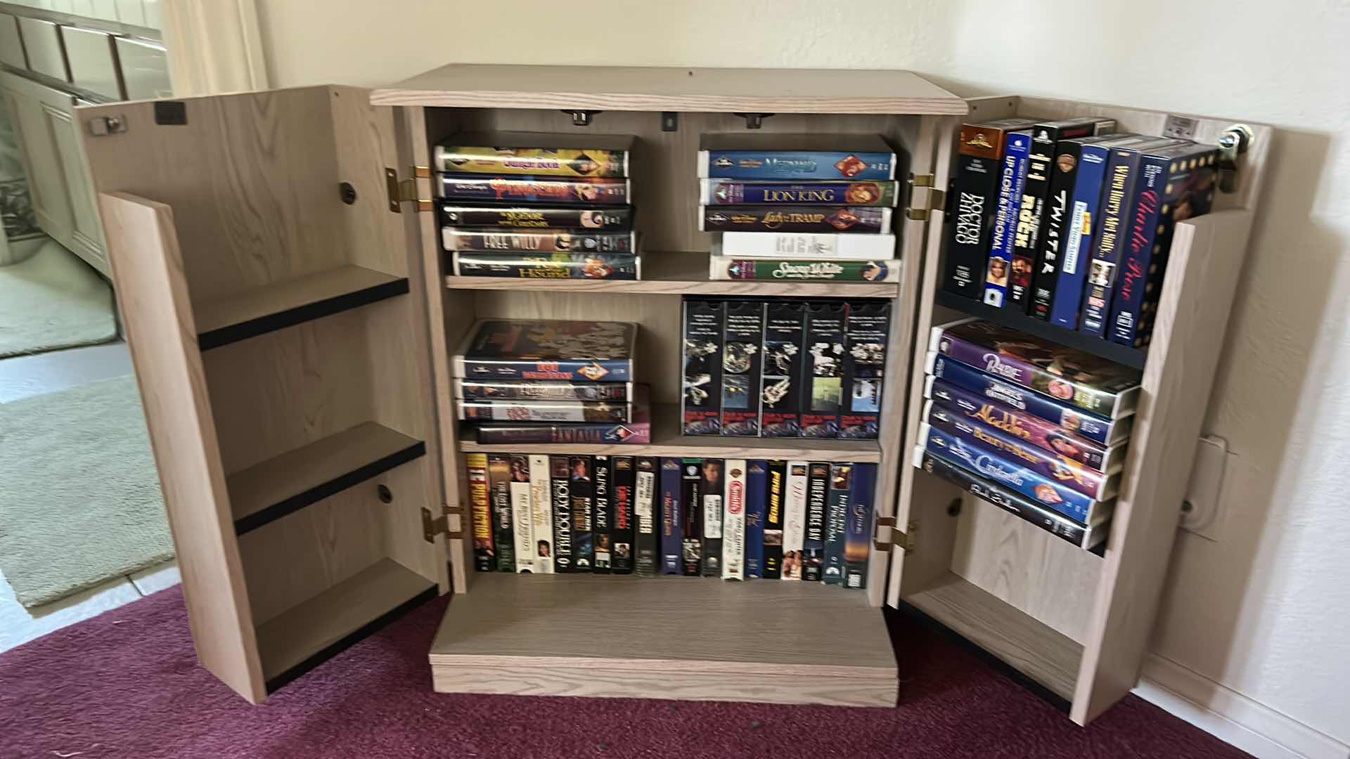 Photo 1 of LOCKING CABINET WITH VHS MOVIE COLLECTION 23” x 12” x 29 1/4”