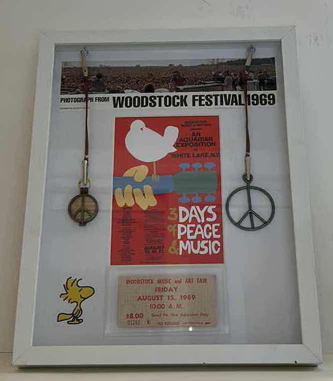 Photo 1 of AUTHENTIC WOODSTOCK FESTIVAL 1969 MEMORABILIA IN ORIGINAL DESIGNED SHADOW BOX. 12“ x 15“INCLUDES WOODSTOCK TICKET, PIECE OF THE GATE AND PIECE OF THE STAGE. GATE AND STAGE CRAFTED INTO PEACE SIGNS. DOCUMENTATION AND AUTHENTICITY PAPERS INCLUDED.