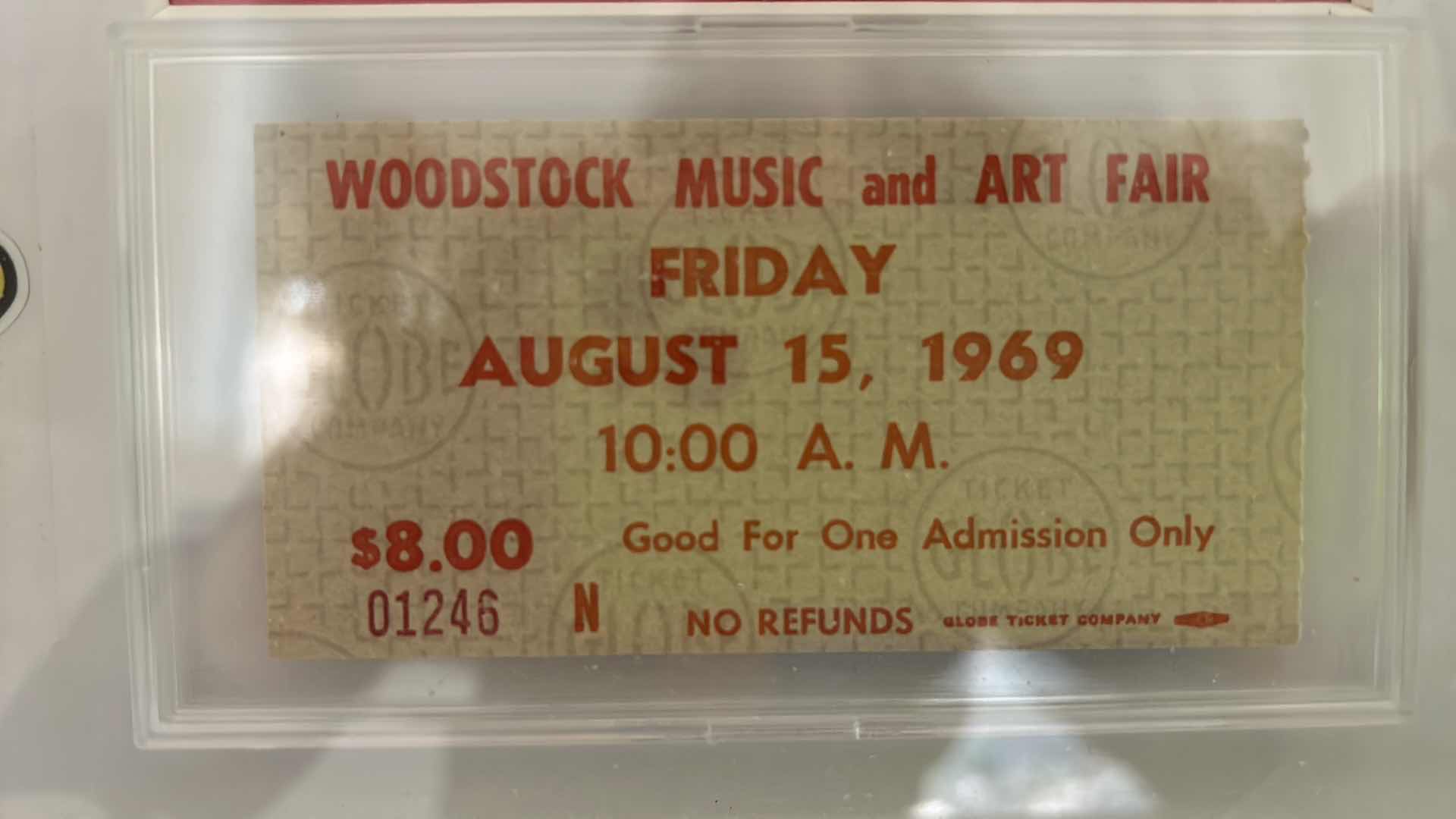 Photo 2 of AUTHENTIC WOODSTOCK FESTIVAL 1969 MEMORABILIA IN ORIGINAL DESIGNED SHADOW BOX. 12“ x 15“INCLUDES WOODSTOCK TICKET, PIECE OF THE GATE AND PIECE OF THE STAGE. GATE AND STAGE CRAFTED INTO PEACE SIGNS. DOCUMENTATION AND AUTHENTICITY PAPERS INCLUDED.