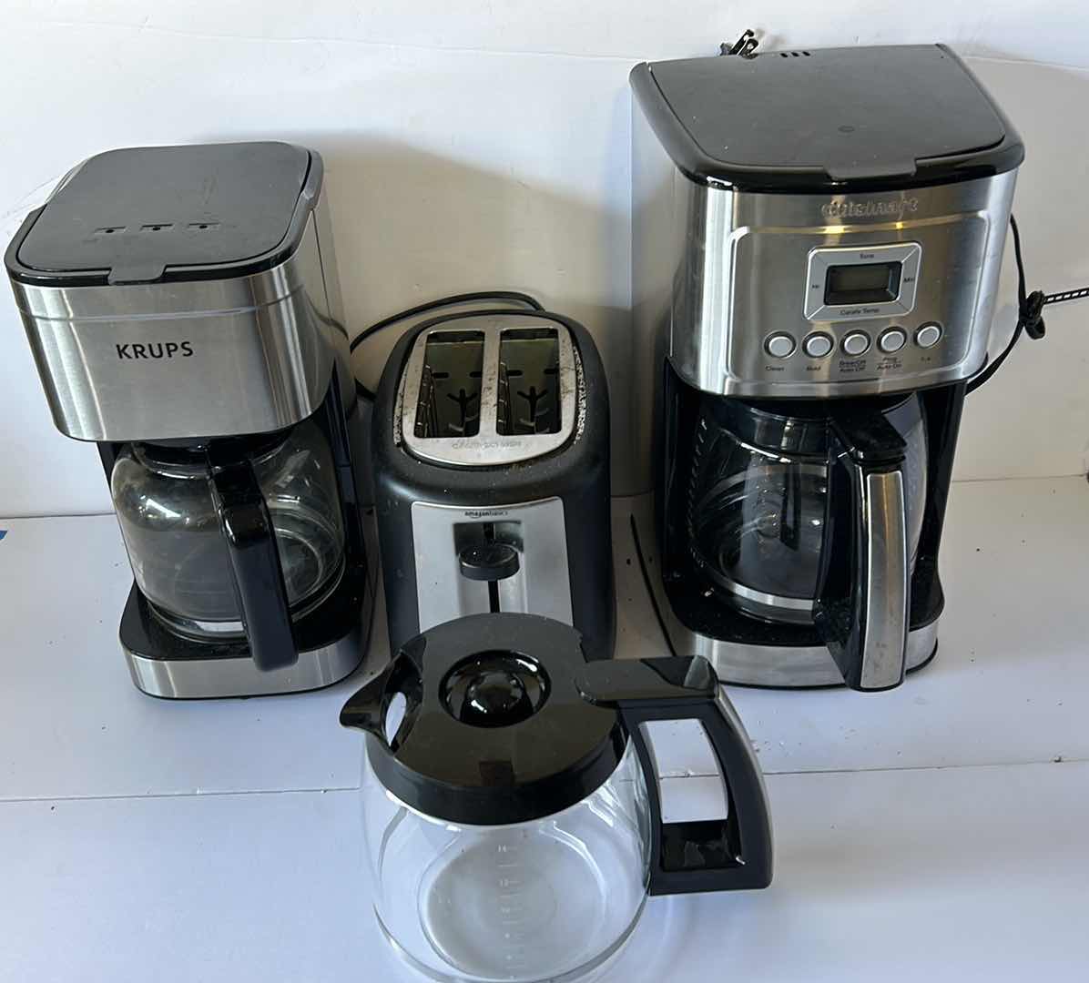 Photo 7 of HOUSEHOLD APPLIANCES. TWO COFFEE MAKERS, AN EXTRA COFFEE POT, AND A TOASTER.