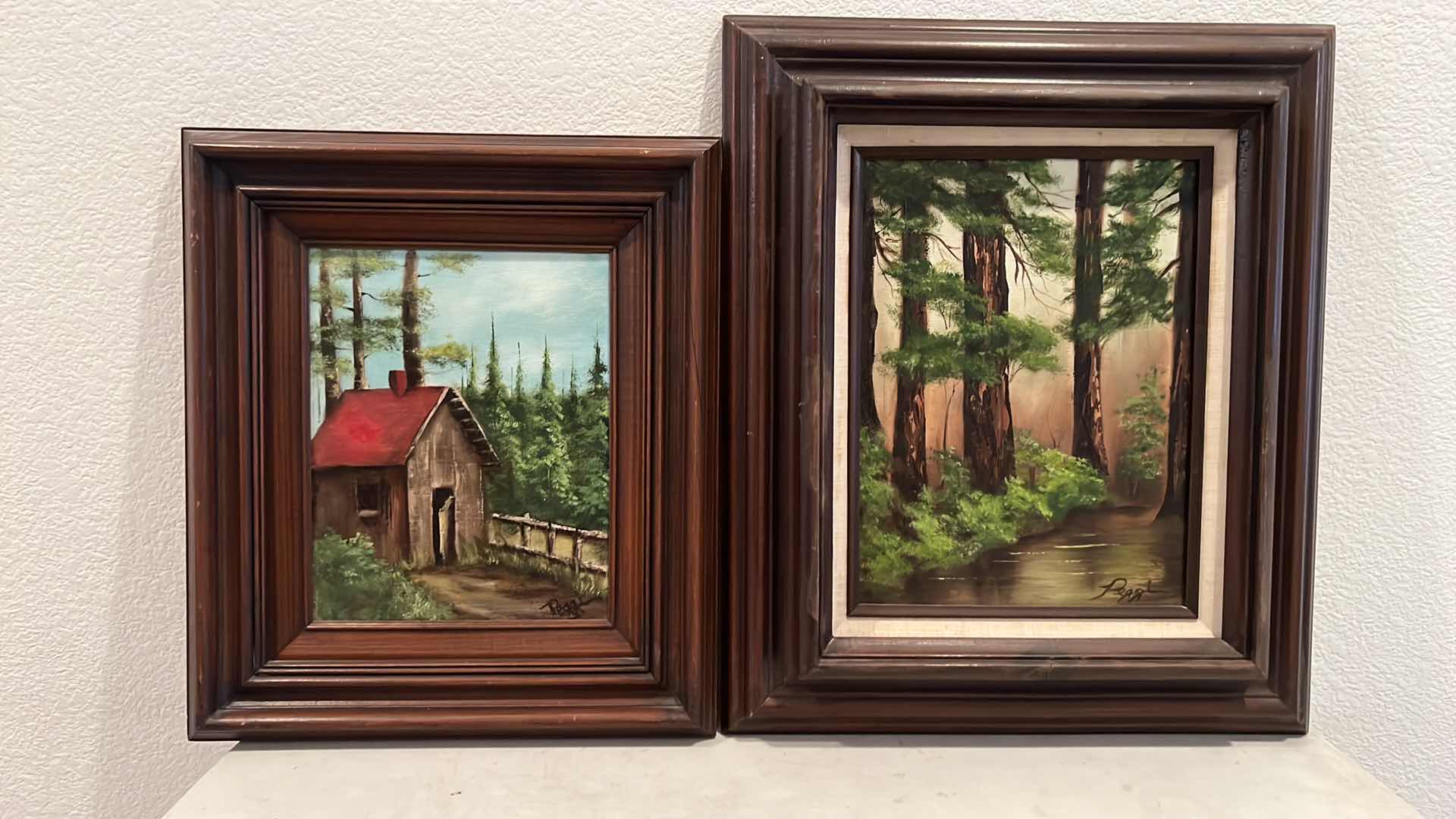 Photo 1 of 2-WOOD FRAMED CANVAS “CABIN & WOODED TREES” OIL PAINTINGS-ARTIST SIGNED (16” x 19” & 14” x 16”)