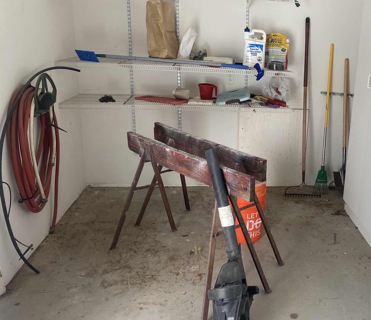 Photo 1 of SAWHORSES BUCKETS TOOLS AND ITEMS ON BACK WALL IN SHED
