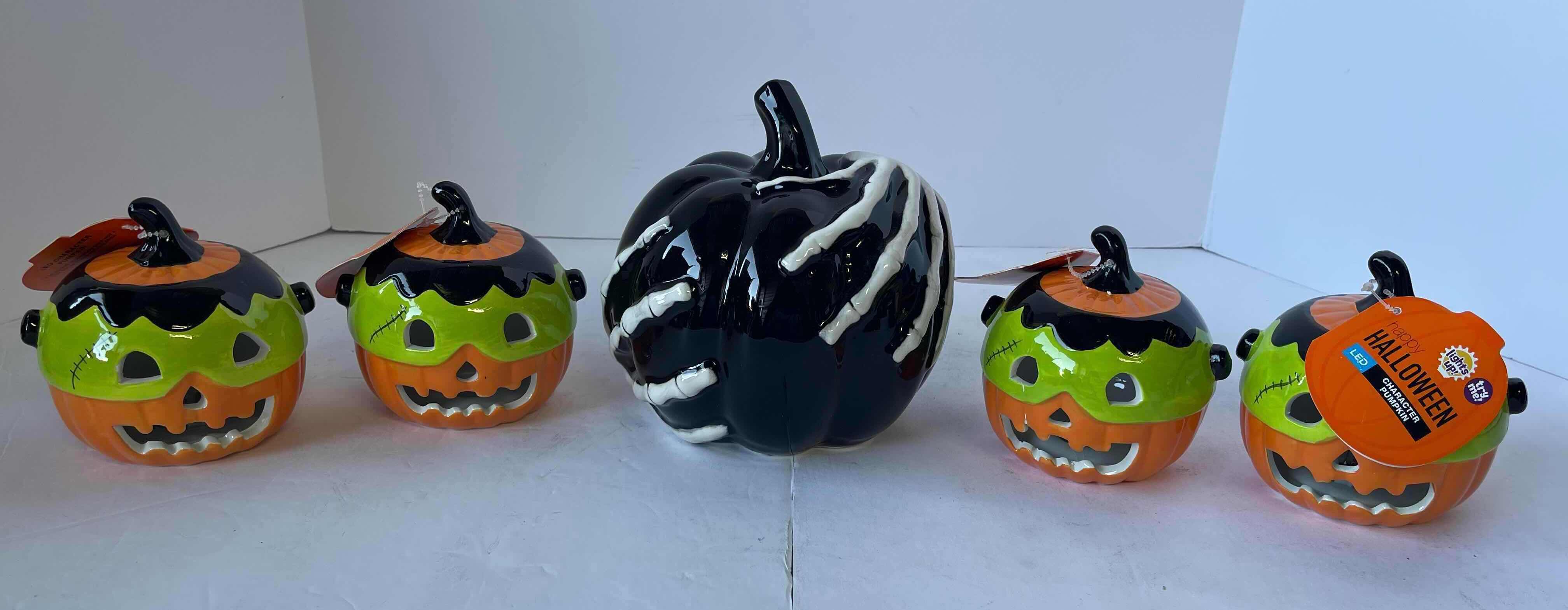 Photo 1 of HAPPY HALLOWEEN 4” MINI CERAMIC LIGHT UP PUMPKINS (4) & BLACK 6” SKELETON HAND PUMPKIN