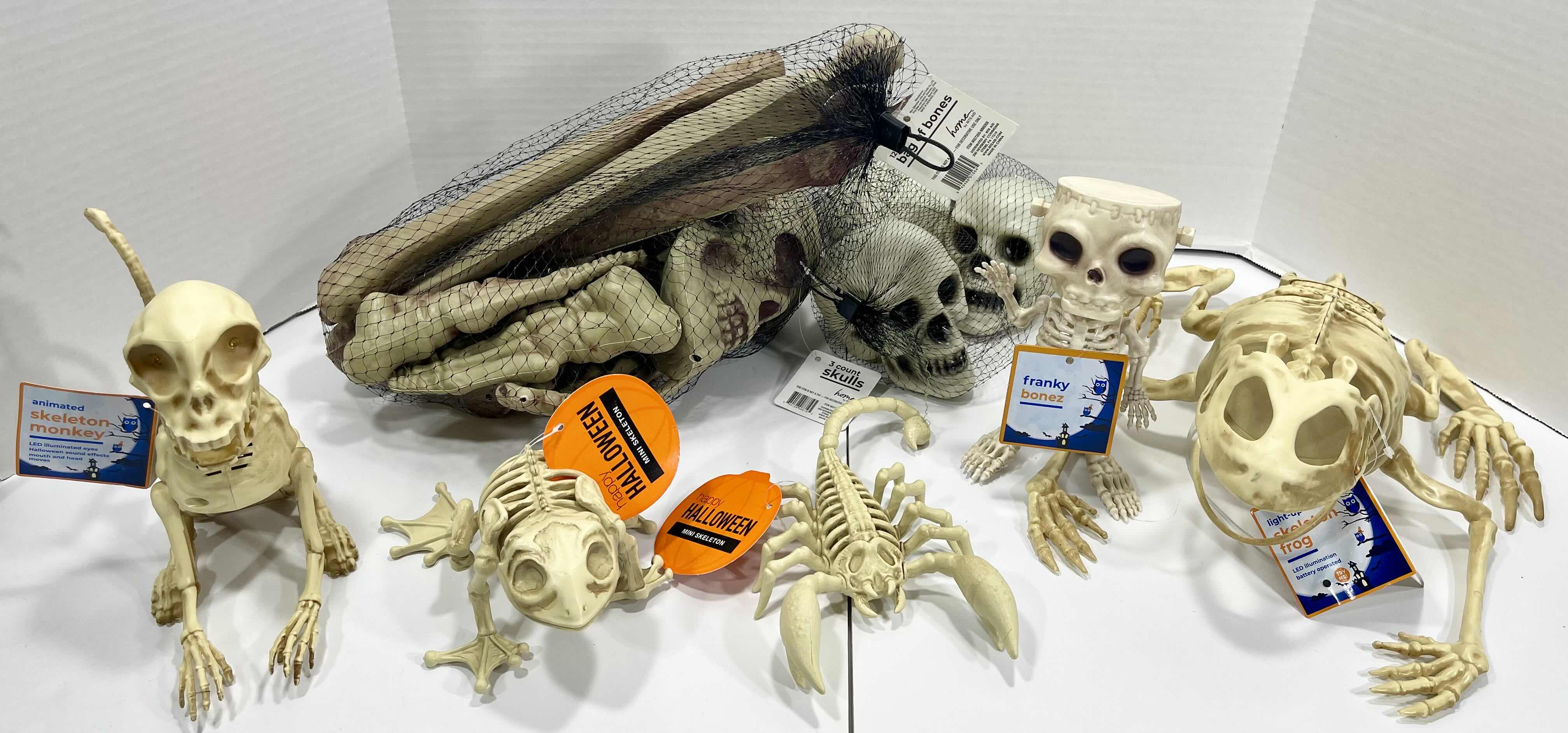 Photo 1 of HALLOWEEN FROG SKELETON LIGHT-UP, ANIMATED MONKEY, MINI SKELETONS SKULLS & BAG OF BONES YARD/HOME DECORATIONS (7 ITEMS) MSRP $100