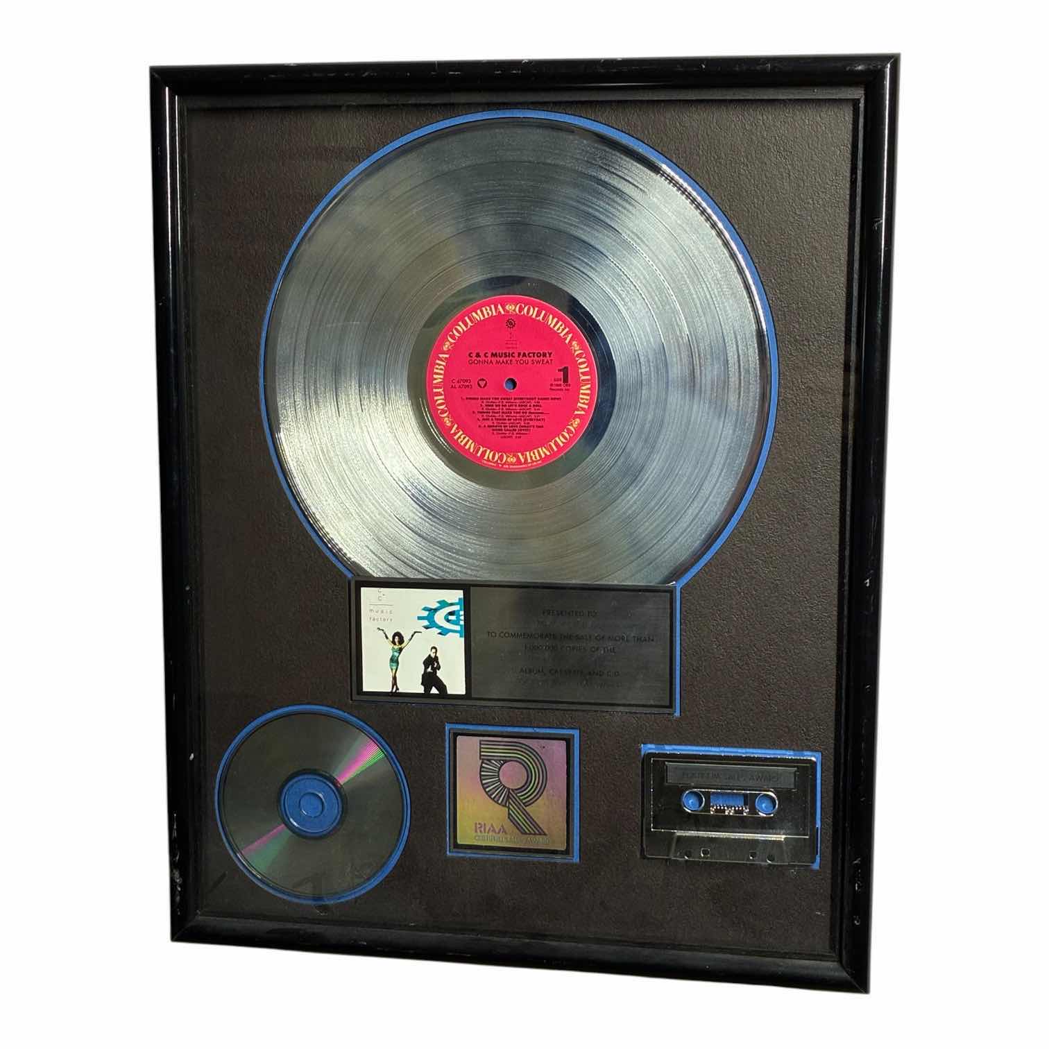 Photo 1 of PLATINUM RECORD PRESENTED TO MARC KORDELOS TO COMMEMORATE THE SALE OF MORE THAN $1M COPIES OF THE COLUMBIA RECORDS ALBUM, CASSETTE & CD
"GONNA MAKE YOU SWEAT" FRAMED PLAQUE 17“ X 21“