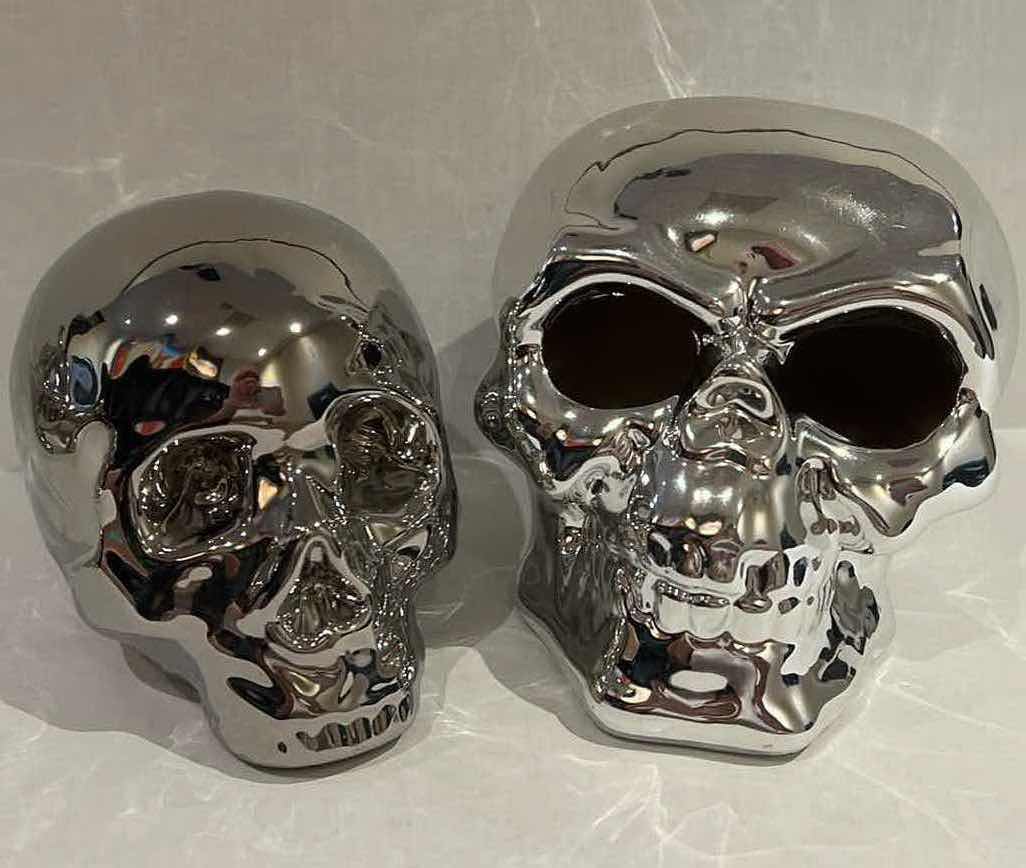 Photo 1 of 2-SILVER CERAMIC SKULLS. SMALLER ONE IS A PIGGY BANK, H5” LARGER SKULL LIGHTS UP, H6”