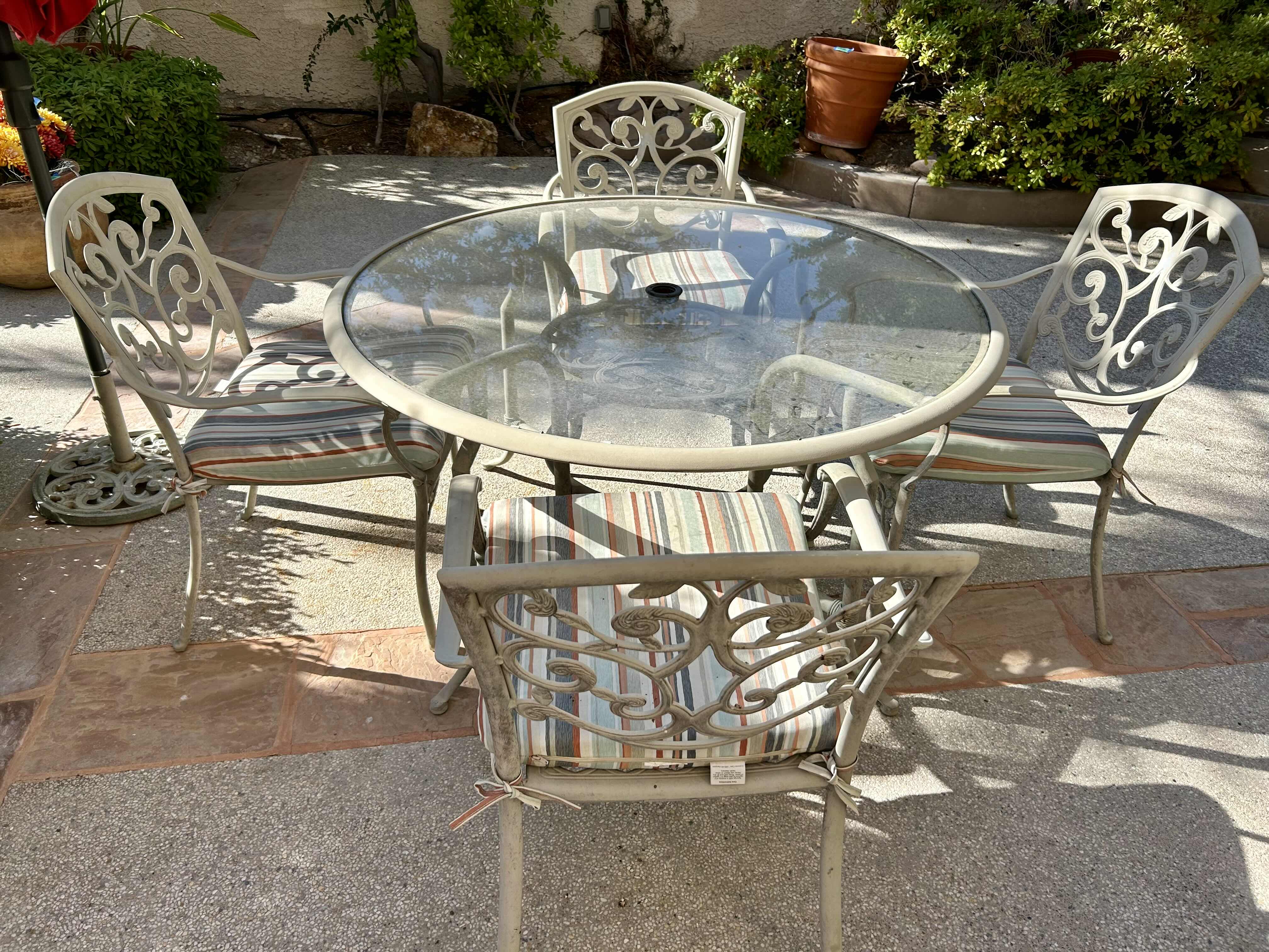 Photo 1 of 50” METAL PATIO TABLE SET WITH GLASS TOP AND 4 CHAIRS WITH STRIPED CUSHIONS