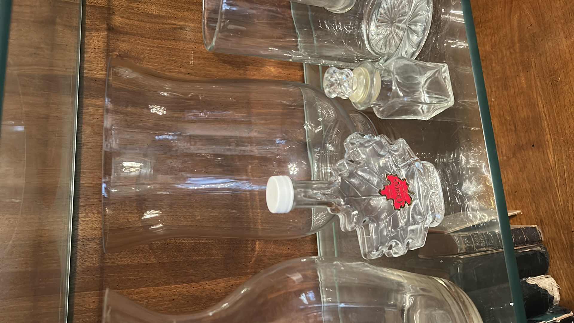 Photo 1 of 12 GLASS PIECES- VINTAGE GLASSWARE INCLUDES A VARIETY OF CLEAR GLASS LIDDED JARS, VASES, AND BOTTLES FROM THE 1950S TO THE 1970S.