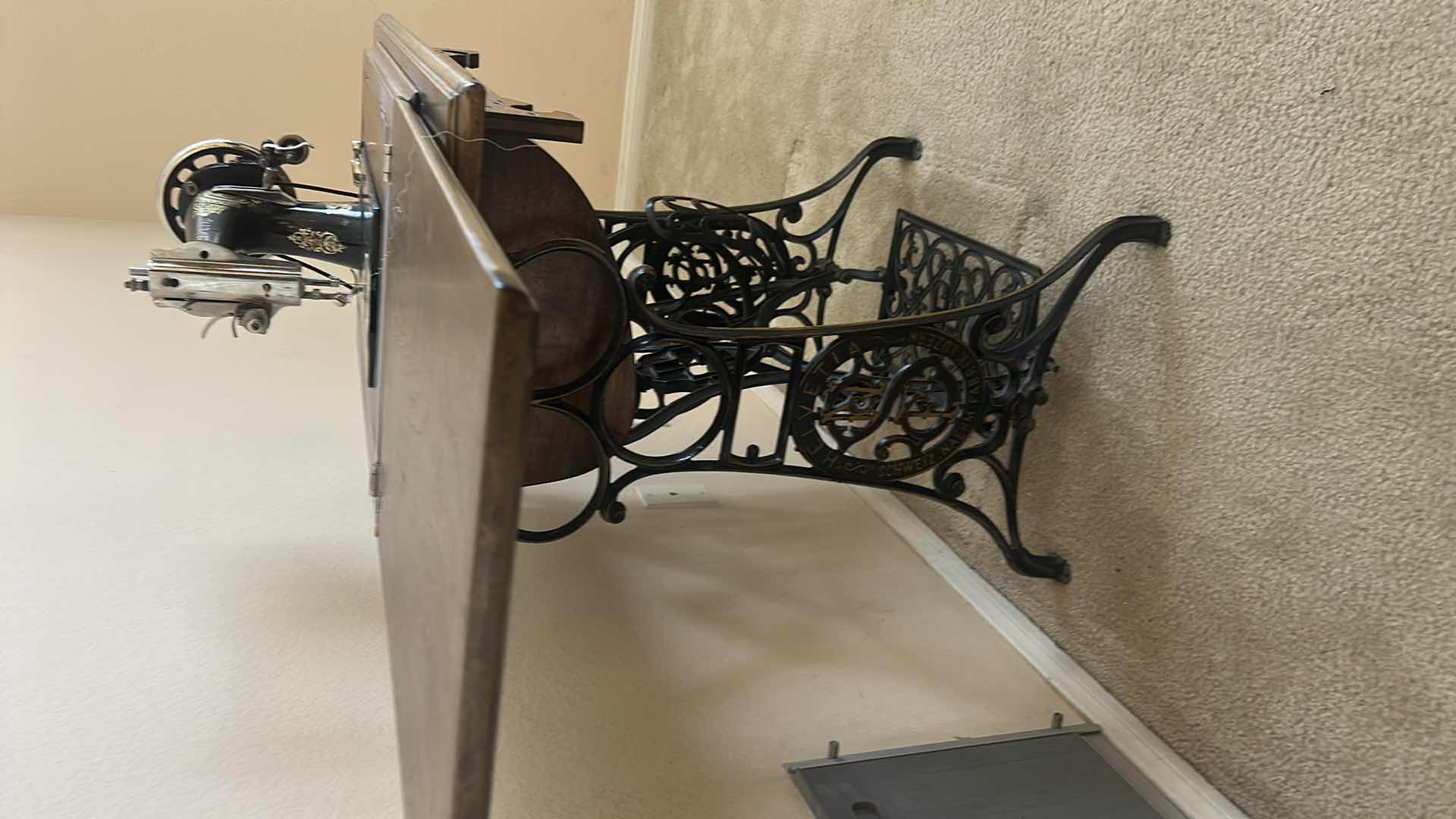 Photo 1 of ANTIQUE HELVETIA TREADLE SEWING MACHINE AND CABINET, ORNATE CAST IRON AND GOLD DETAILING PLUS PARTS. INCLUDES CAST IRON TREADLE BASE, SEWING MACHINE HEAD, WOOD TABLE TOP, DRAWERS, AND LOOSE WOOD COMPONENTS.
36 1/2“ x 18 1/2“ x H32“