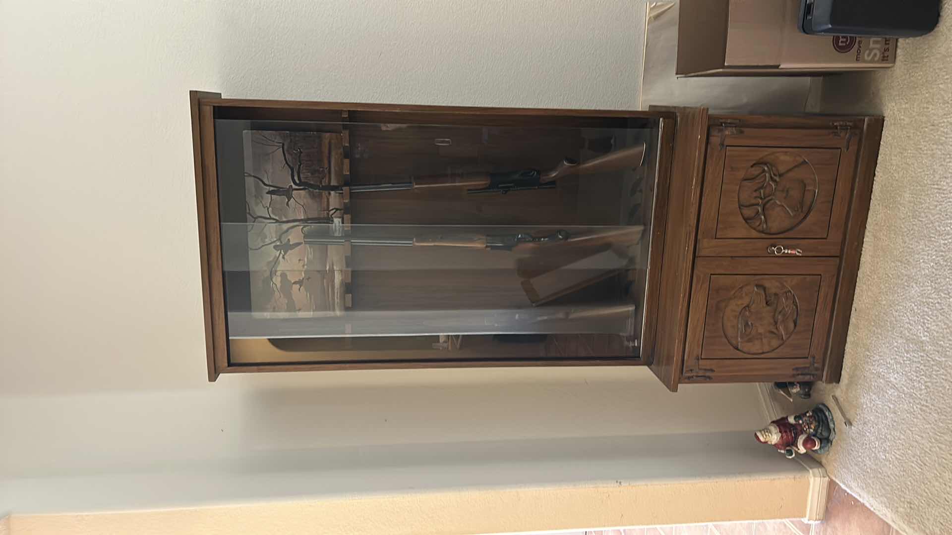Photo 1 of WOODEN GUN CABINET WITH GLASS FRONT. FEATURES CARVED WOOD DOORS ON LOWER CABINET AND LOCKING STORAGE. DESIGNED TO DISPLAY AND STORE FIREARMS. HOLDS 8, LOWER CABINET 33 1/4 x 16“ x H22“ , TOP CABINET 32“ x 10 1/2“ x H54 1/2“