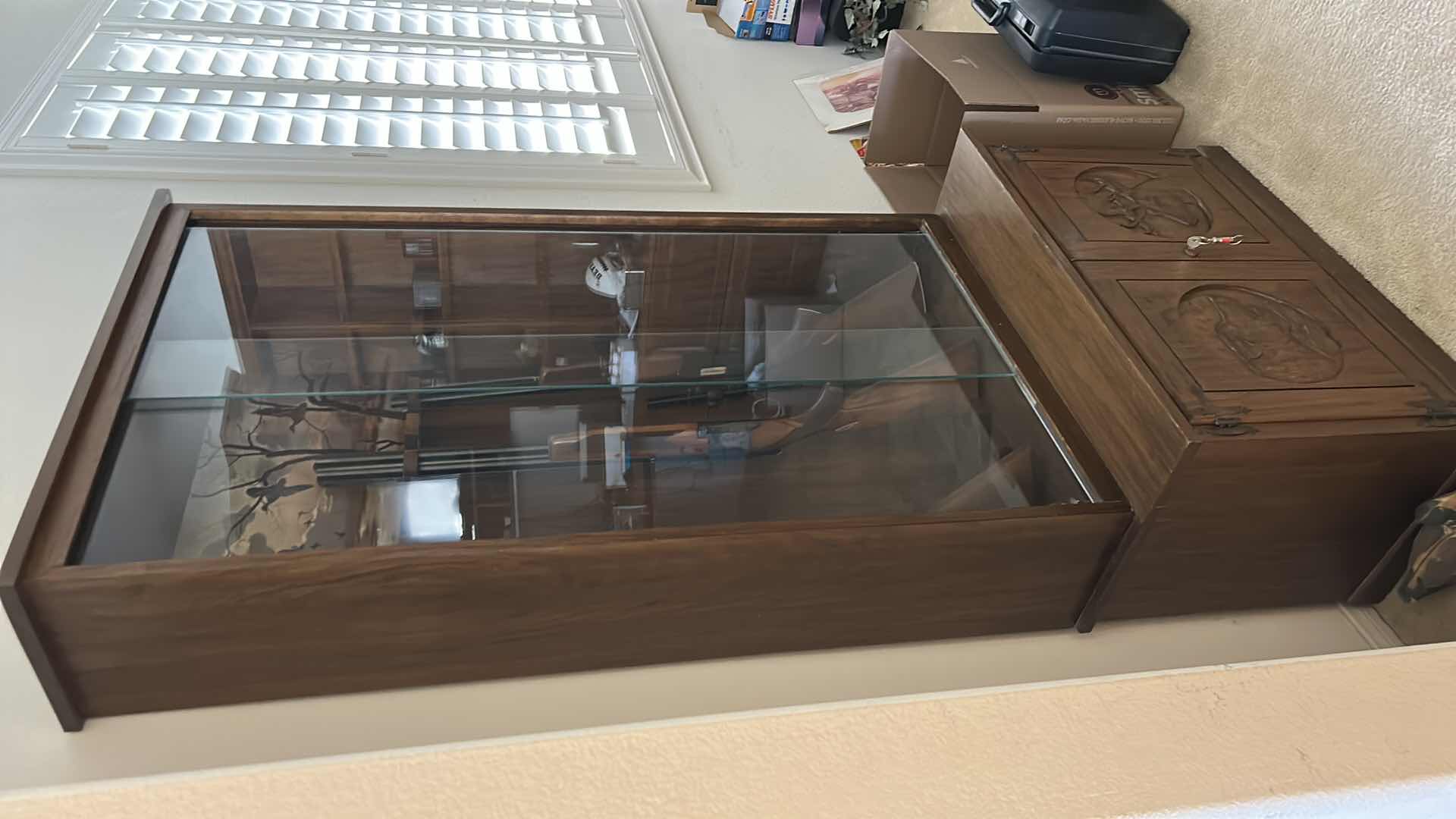 Photo 1 of WOODEN GUN CABINET WITH GLASS FRONT. FEATURES CARVED WOOD DOORS ON LOWER CABINET AND LOCKING STORAGE. DESIGNED TO DISPLAY AND STORE FIREARMS. HOLDS 8, LOWER CABINET 33 1/4 x 16“ x H22“ , TOP CABINET 32“ x 10 1/2“ x H54 1/2“