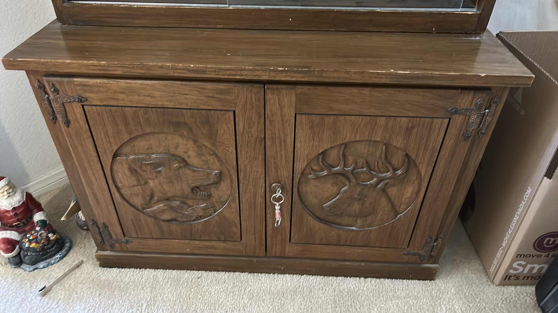 Photo 1 of WOODEN GUN CABINET WITH GLASS FRONT. FEATURES CARVED WOOD DOORS ON LOWER CABINET AND LOCKING STORAGE. DESIGNED TO DISPLAY AND STORE FIREARMS. HOLDS 8, LOWER CABINET 33 1/4 x 16“ x H22“ , TOP CABINET 32“ x 10 1/2“ x H54 1/2“
