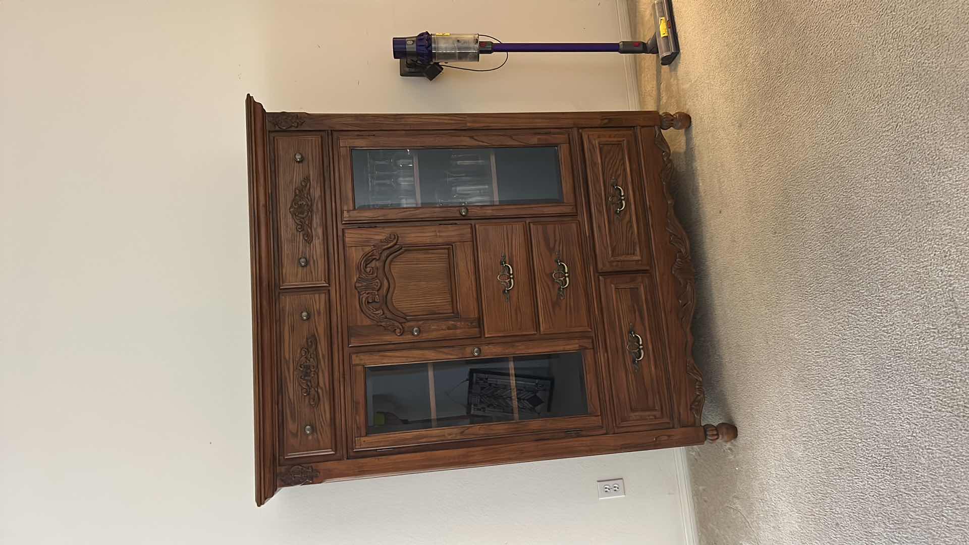 Photo 1 of TRADITIONAL CARVED WOOD HUTCH OR ARMOIRE, OFTEN REFERRED TO AS A CHINA CABINET. FEATURES DARK CHERRY OR WALNUT FINISH WITH GLASS-PANELED DOORS AND DRAWERS FOR STORAGE. 54 1/2” x 19” x H65” TONGUE AND GROOVE