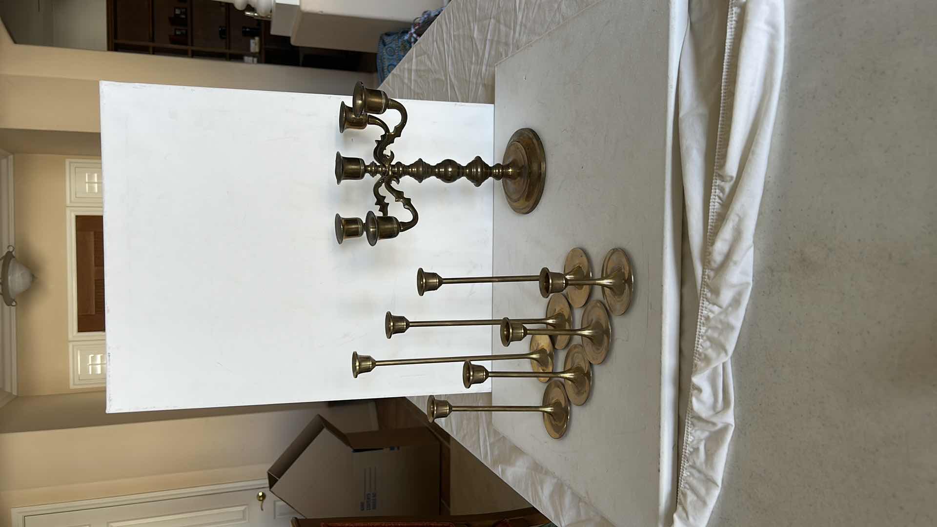 Photo 1 of BRASS CANDLE HOLDERS AND CANDLE ACCESSORIES. INCLUDES MULTIPLE TALL TAPER HOLDERS, A MULTI-ARM CANDELABRA H10” AND A BRASS CUP.