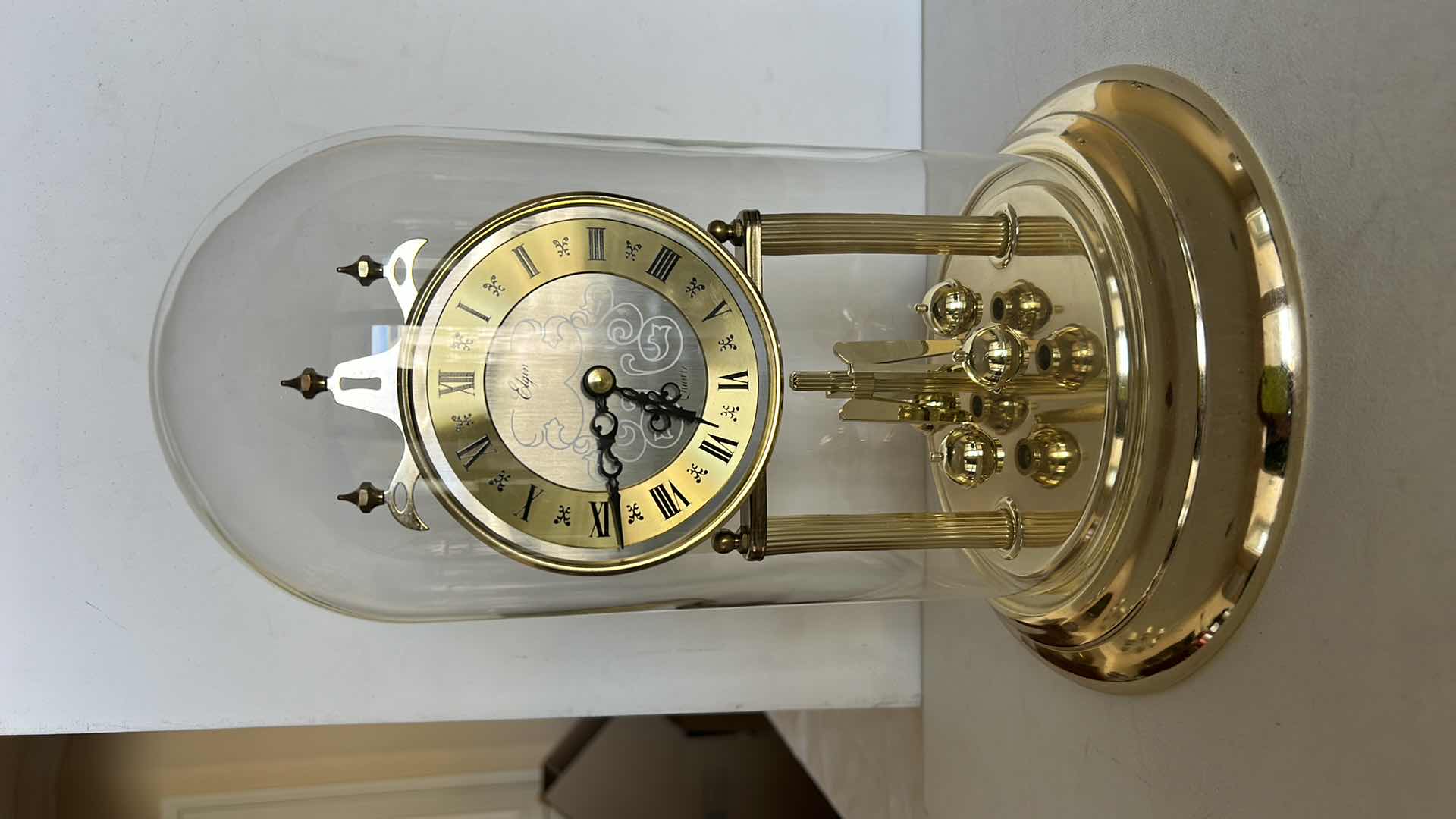 Photo 1 of ELGIN QUARTZ ANNIVERSARY CLOCK WITH GLASS DOME. BRASS-TONE FRAME WITH ROUND CLOCK FACE AND ROTATING PENDULUM BALLS. H12”