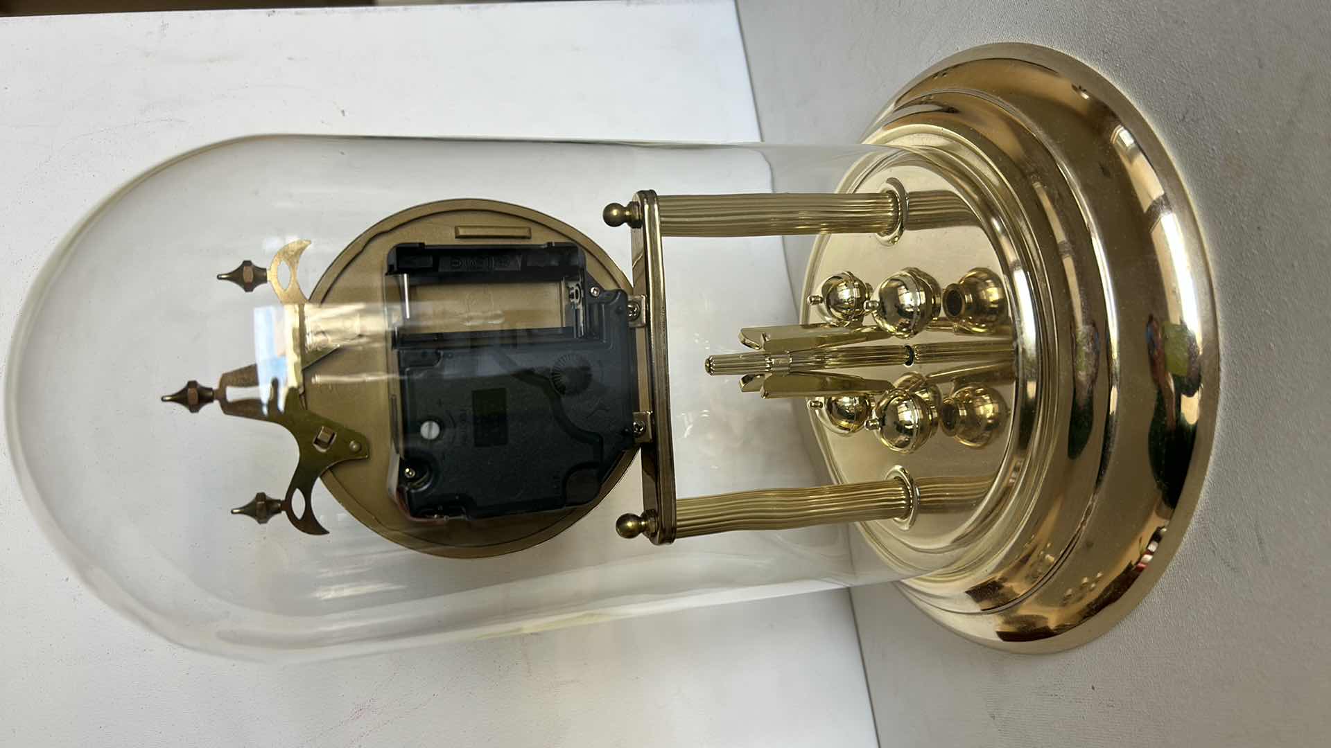 Photo 1 of ELGIN QUARTZ ANNIVERSARY CLOCK WITH GLASS DOME. BRASS-TONE FRAME WITH ROUND CLOCK FACE AND ROTATING PENDULUM BALLS. H12”