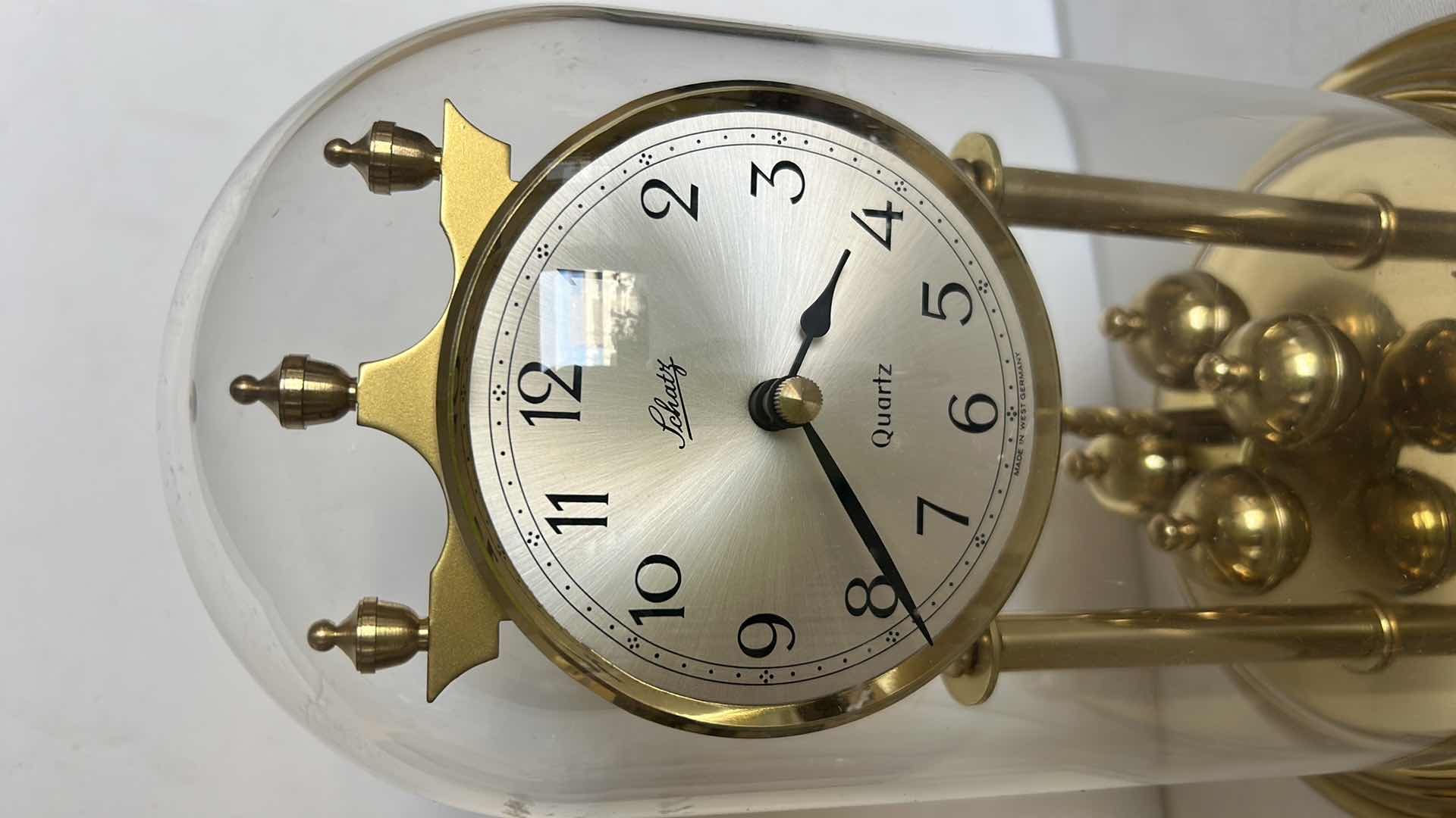 Photo 1 of SCHATZ QUARTZ ANNIVERSARY CLOCK WITH GLASS DOME. BRASS-TONE FRAME WITH ROTATING PENDULUM BALLS AND ROUND CLOCK FACE H 9 1/2”