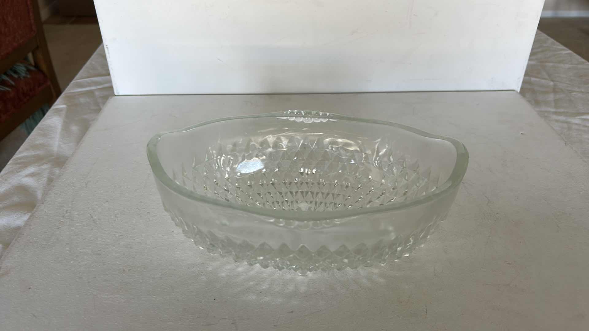 Photo 1 of SET OF TWO CLEAR PRESSED GLASS BOWLS. ONE OVAL SERVING BOWL AND ONE PEDESTAL BOWL H4.25”WITH CUT PATTERN DESIGN.