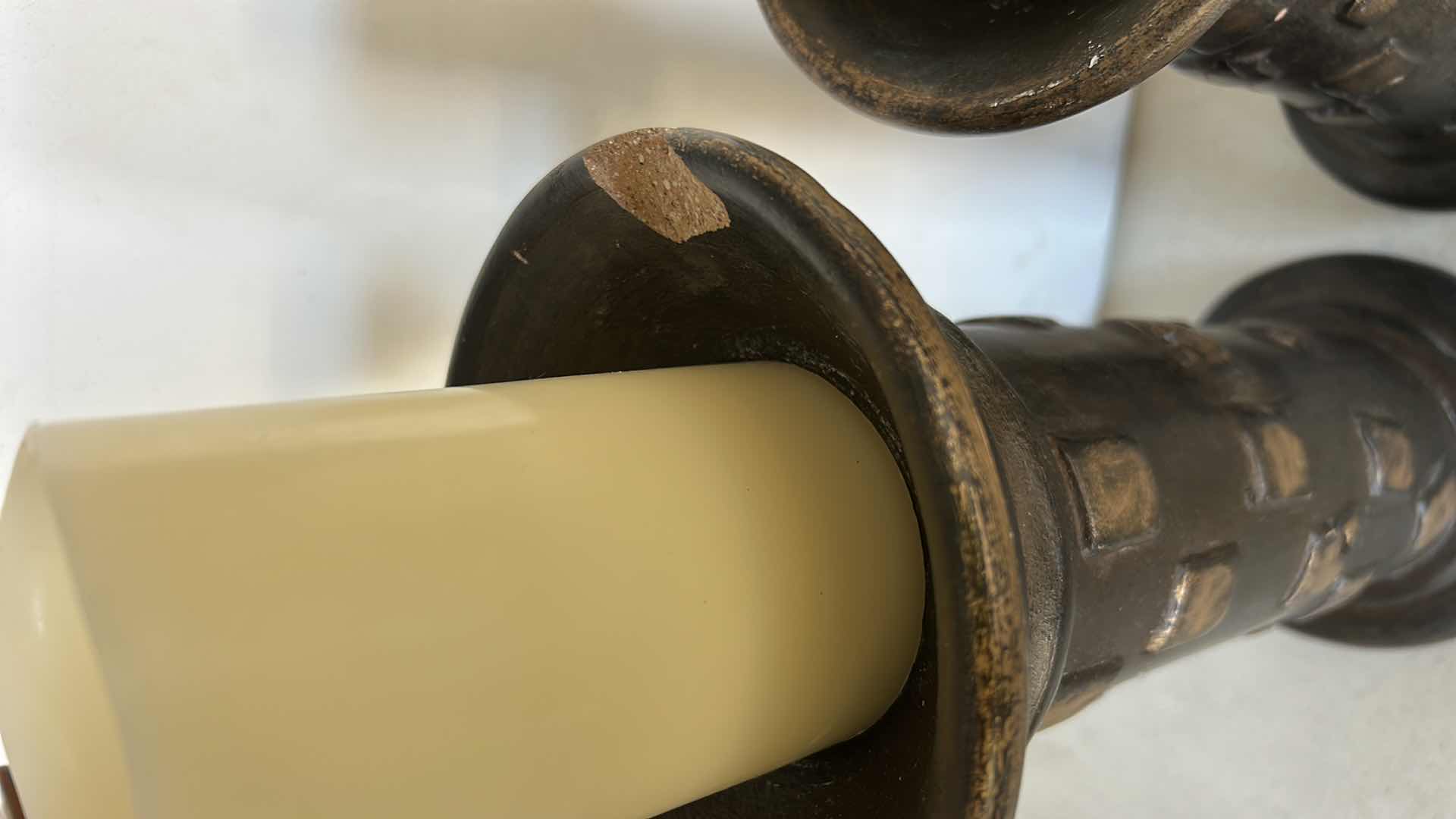 Photo 1 of SET OF THREE DECORATIVE PILLAR CANDLE HOLDERS. MADE OF HEAVY POTTERY WITH A DARK BRONZE-TONE FINISH AND TEXTURED DESIGN. EACH HOLDS A PILLAR-STYLE CANDLE. (TALLEST H13”)