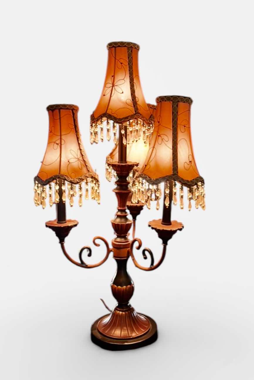 Photo 1 of THREE-LIGHT TABLE LAMP WITH METAL BASE AND SCROLL ARMS, ORANGE FABRIC SHADES WITH BEADED FRINGE H29.5”