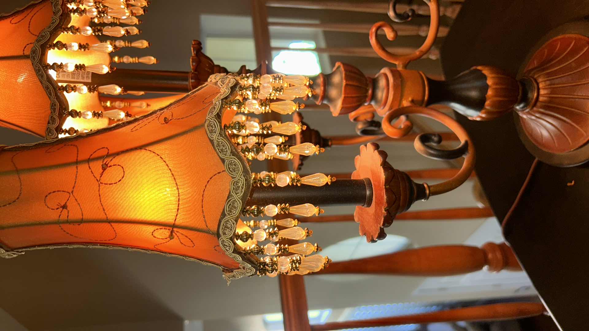 Photo 1 of THREE-LIGHT TABLE LAMP WITH METAL BASE AND SCROLL ARMS, ORANGE FABRIC SHADES WITH BEADED FRINGE H29.5”