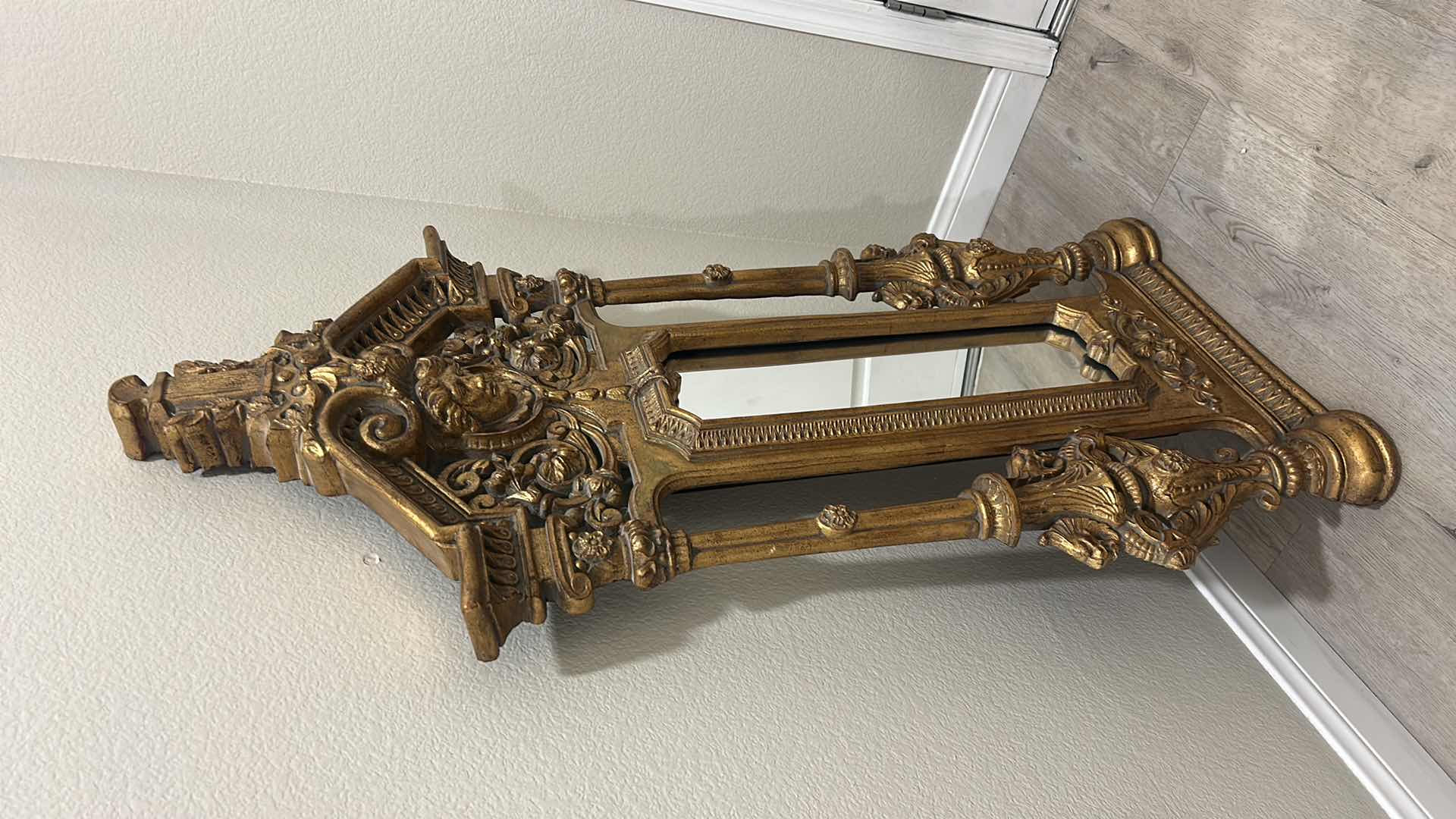 Photo 1 of ITALIAN BAROQUE-STYLE FIGURAL MIRROR FEATURING A GOLD GILT FINISH, A LARGE CENTRAL FEMALE FACE CREST, AND WINGED GRIFFINS ON THE BASE. 25” x H53“
