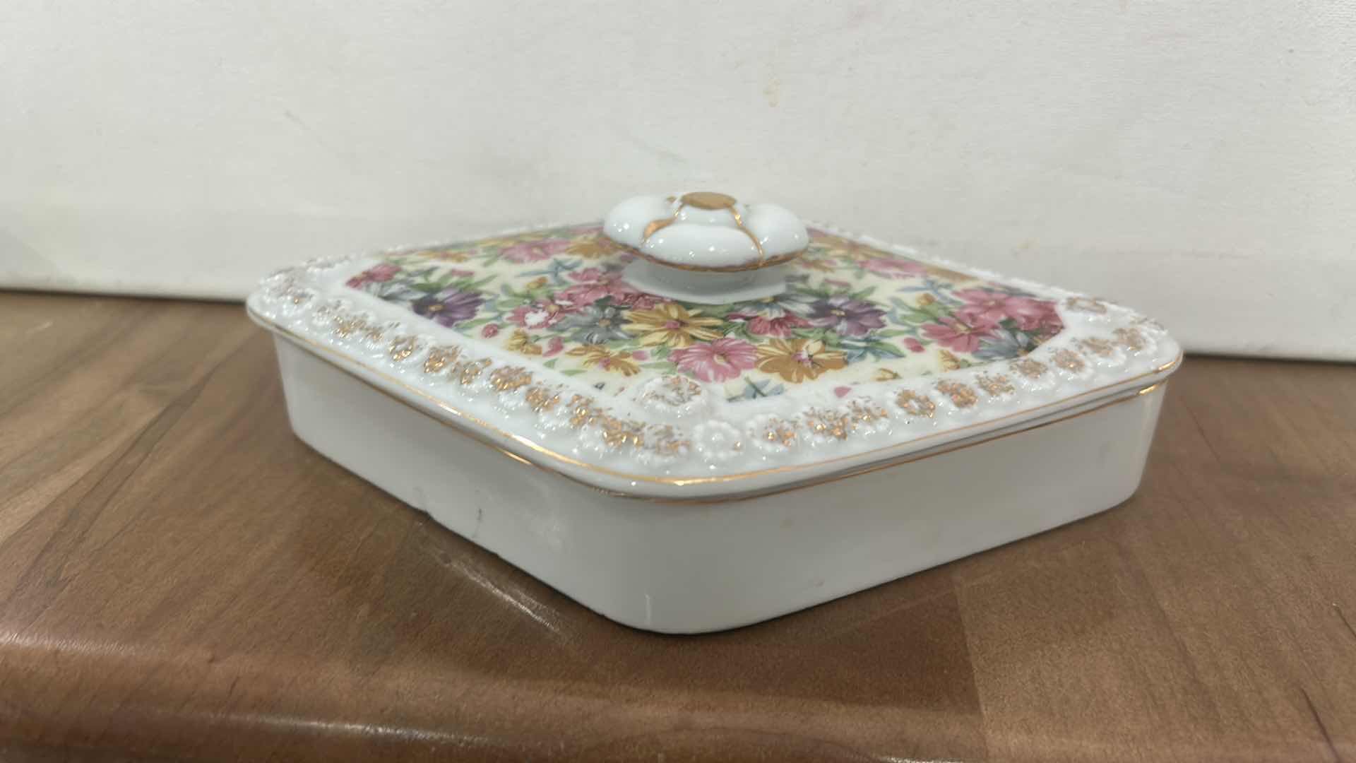Photo 1 of VINTAGE DIAMOND-SHAPED PORCELAIN TRINKET BOX WITH FLORAL PATTERN ON LID.