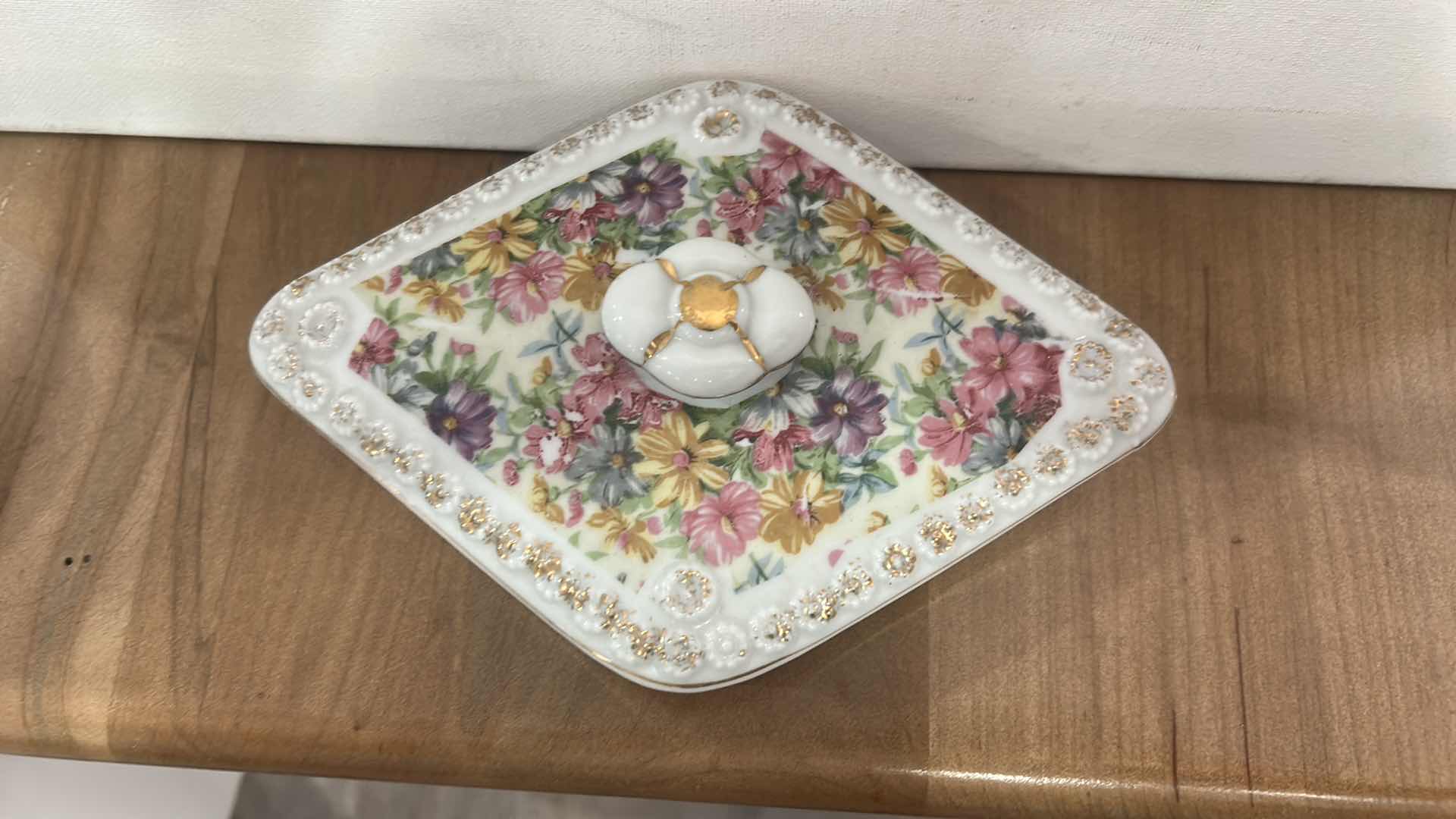 Photo 1 of VINTAGE DIAMOND-SHAPED PORCELAIN TRINKET BOX WITH FLORAL PATTERN ON LID.