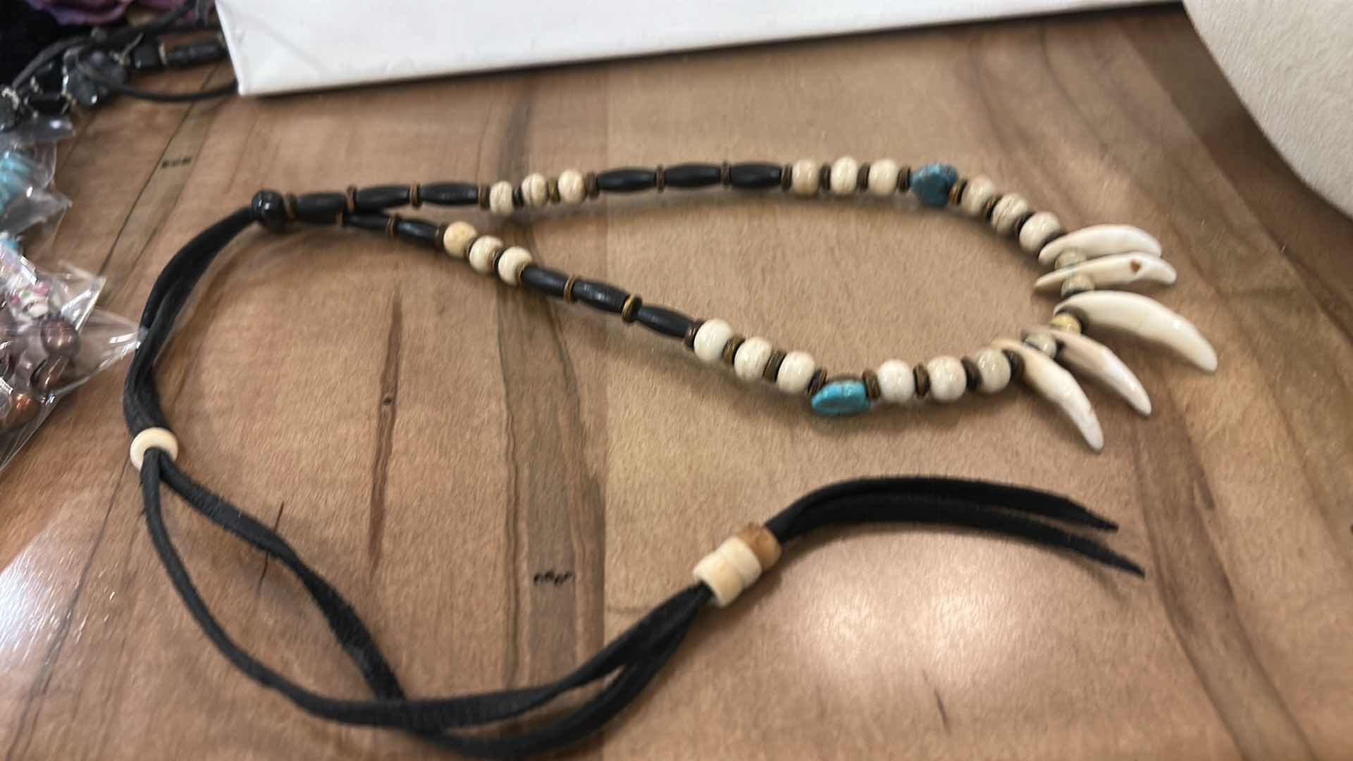 Photo 1 of SHAMAN STYLE NECKLACE FEATURING A COMBINATION OF NATURAL ELEMENTS, COMMONLY INCLUDING BUFFALO BONE BEADS, TURQUOISE STONES, AND EITHER ALLIGATOR OR BUFFALO TEETH. SUCH PIECES ARE OFTEN HANDCRAFTED AND MAY INCORPORATE MATERIALS LIKE SINEW AND WOOD ACCENTS.