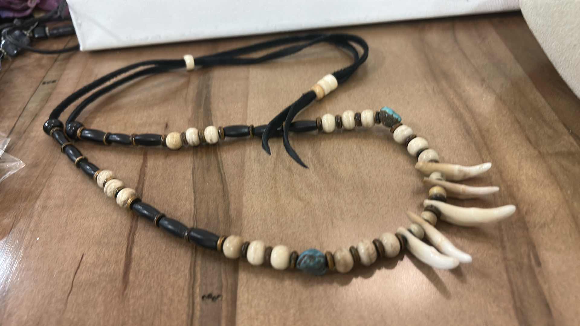 Photo 1 of SHAMAN STYLE NECKLACE FEATURING A COMBINATION OF NATURAL ELEMENTS, COMMONLY INCLUDING BUFFALO BONE BEADS, TURQUOISE STONES, AND EITHER ALLIGATOR OR BUFFALO TEETH. SUCH PIECES ARE OFTEN HANDCRAFTED AND MAY INCORPORATE MATERIALS LIKE SINEW AND WOOD ACCENTS.