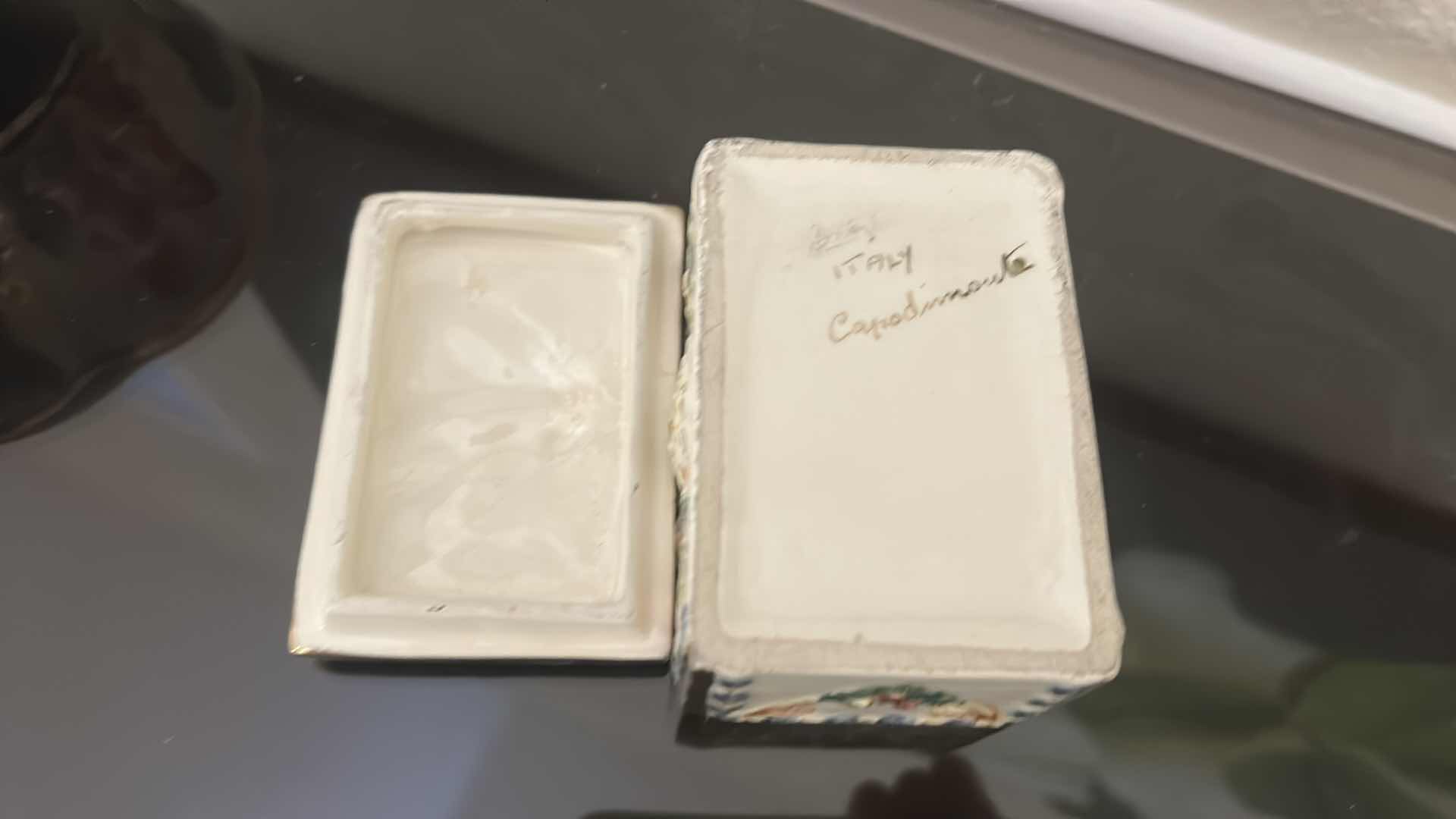 Photo 1 of ANTIQUE CAPODIMONTE ITALIAN PORCELAIN DRESSER SET FEATURING RAISED RELIEF DESIGNS OF CHERUBS .
•THE SET INCLUDES A LARGE LIDDED BOX, A SMALLER LIDDED JEWELRY BOX, AND A SMALL OPEN TRAY. LARGEST 9 1/4” x 7 1/4” x H5 1/2”