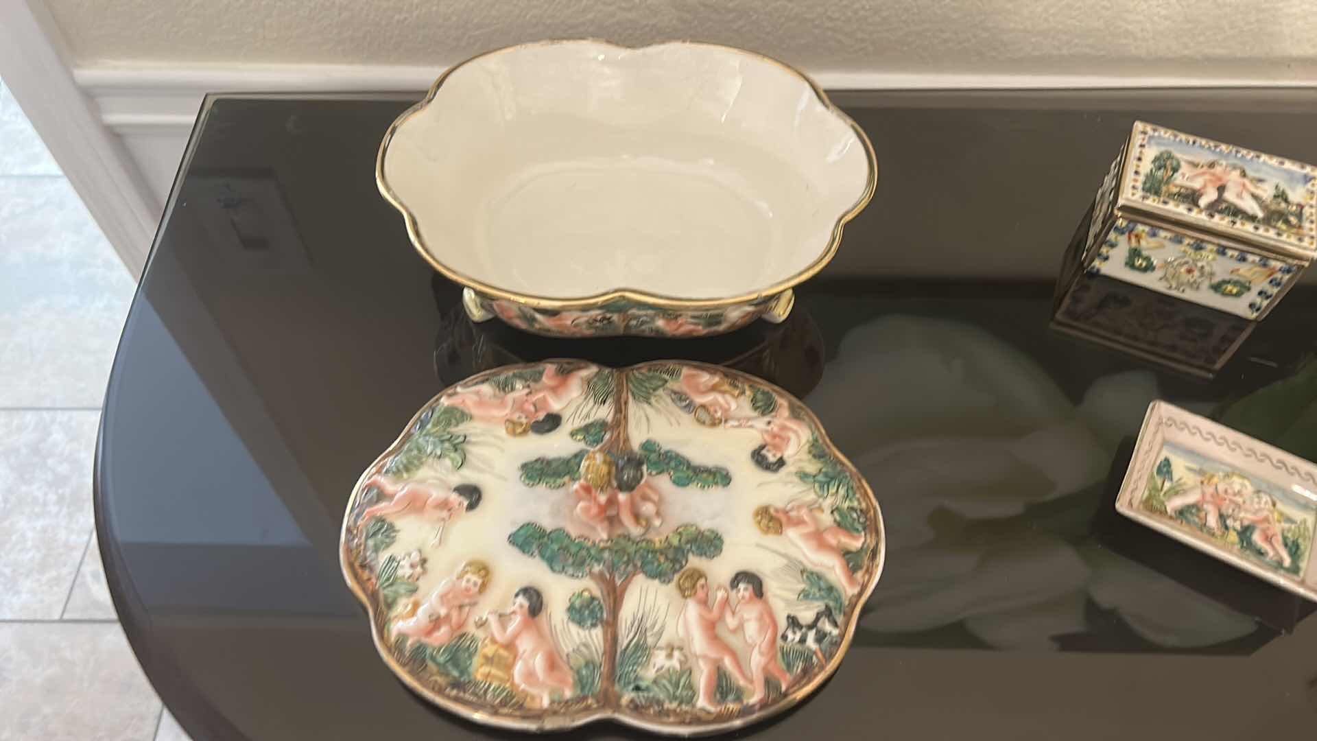 Photo 1 of ANTIQUE CAPODIMONTE ITALIAN PORCELAIN DRESSER SET FEATURING RAISED RELIEF DESIGNS OF CHERUBS .
•THE SET INCLUDES A LARGE LIDDED BOX, A SMALLER LIDDED JEWELRY BOX, AND A SMALL OPEN TRAY. LARGEST 9 1/4” x 7 1/4” x H5 1/2”