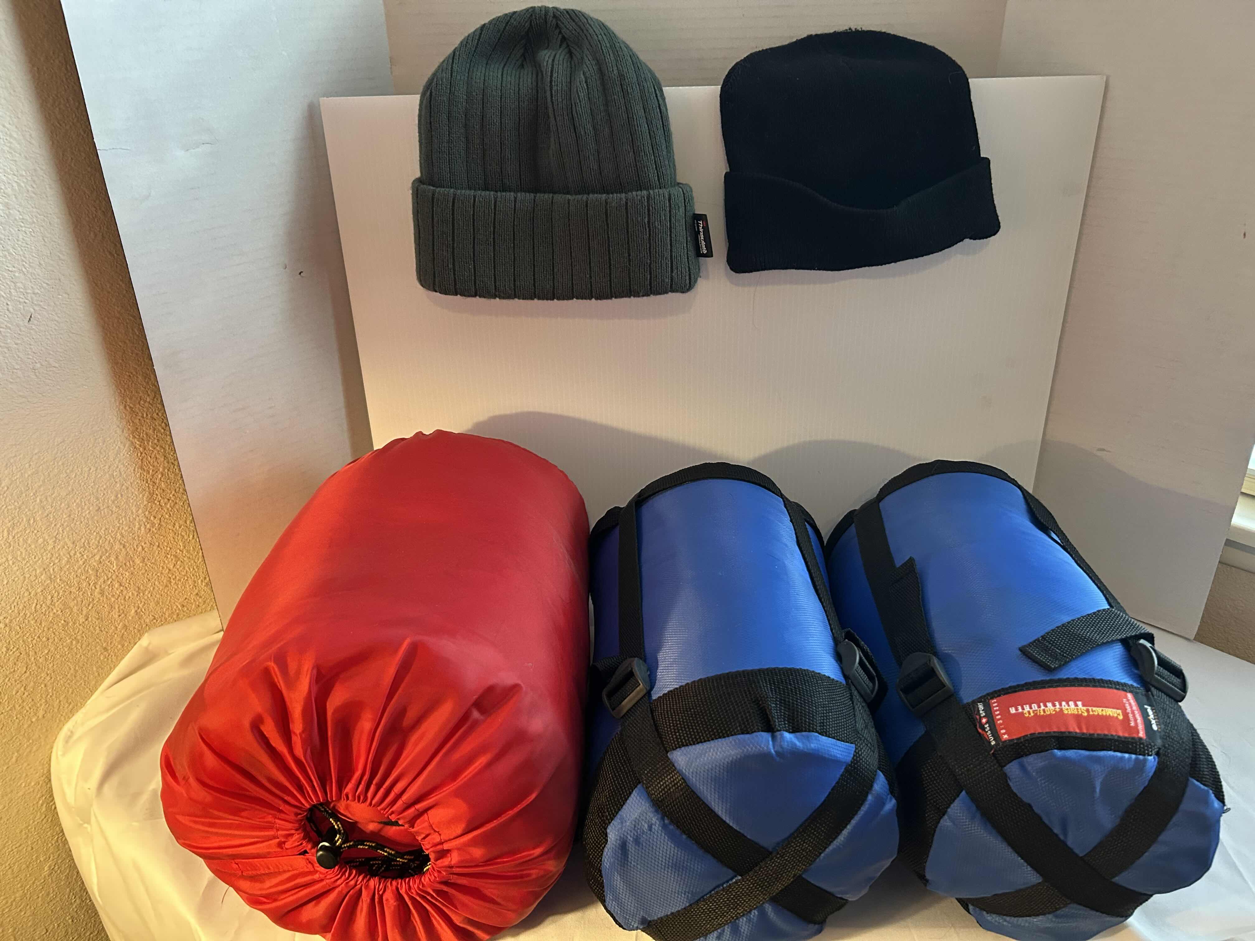 Photo 1 of 3- MICRO PACKED SLEEPING BAGS AND 2 WINTER BEANIES. CAMPING GEAR AND ACCESSORIES.