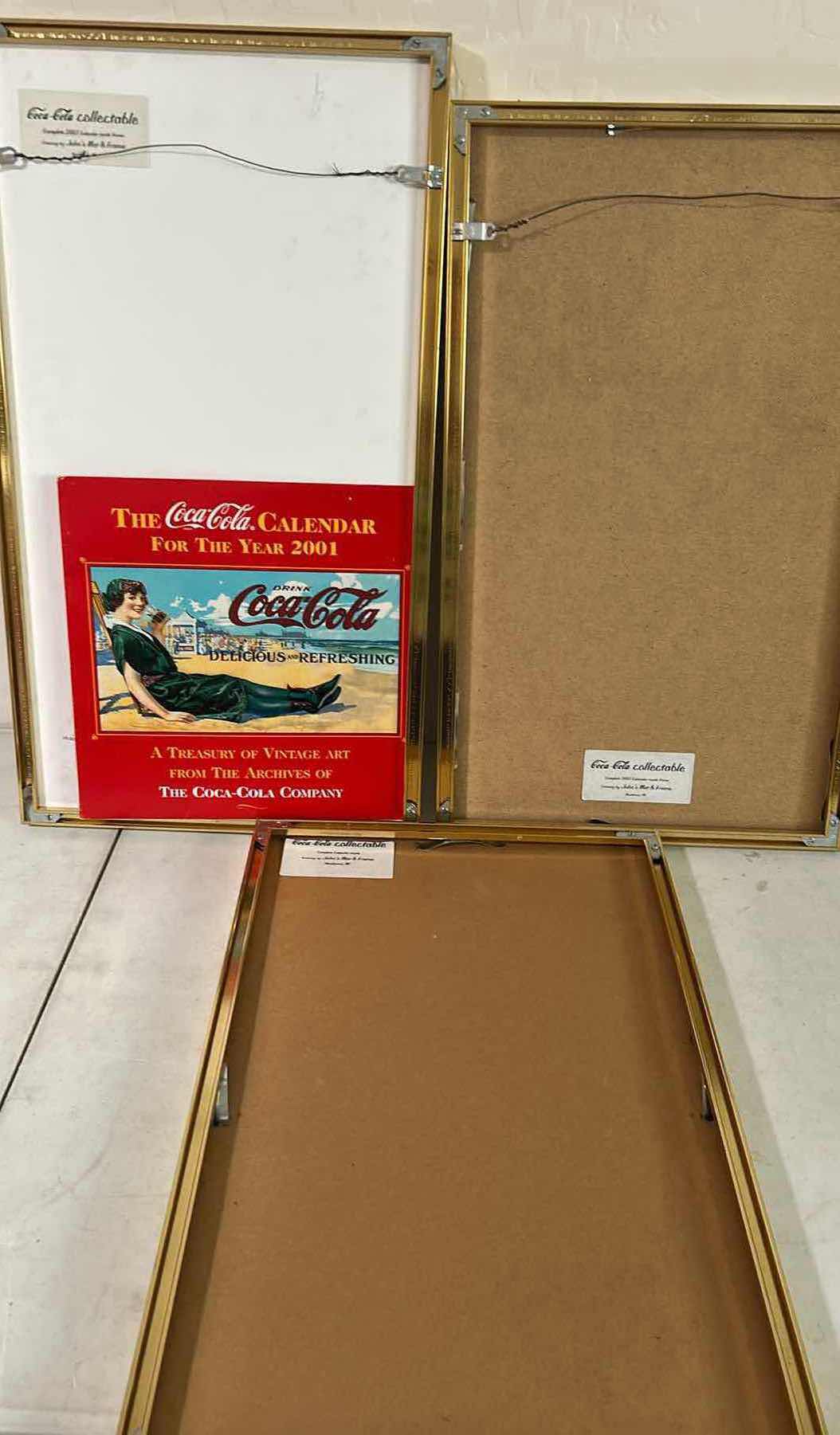 View 5 of THREE VINTAGE FRAMED COCA COLA ADVERTISING CALENDAR PAGES FROM 1973/ 2005
14" X 22" 15" X 26"