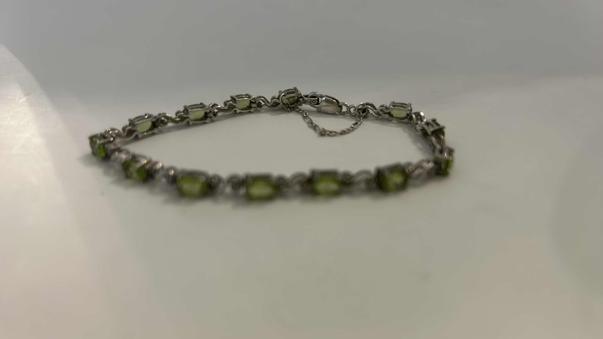 Photo 1 of STERLING SILVER TENNIS BRACELET WITH GREEN GEMSTONES