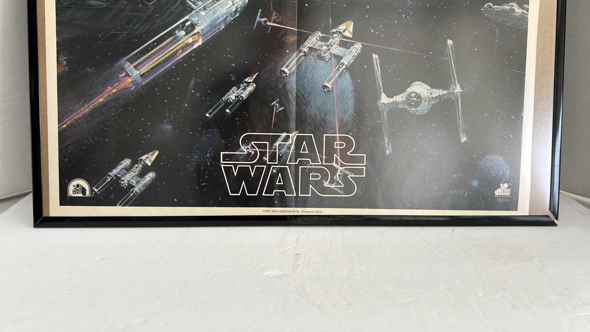 Photo 1 of STAR WARS MOVIE POSTER IN BLACK PLATIC FRAME(22.5”W X 32.5”H) AND STORM TROOPER HELMET HELMET SCHEMATIC IN DARK BROWN WOODEN FRAME(22.5”W X 19”H)
