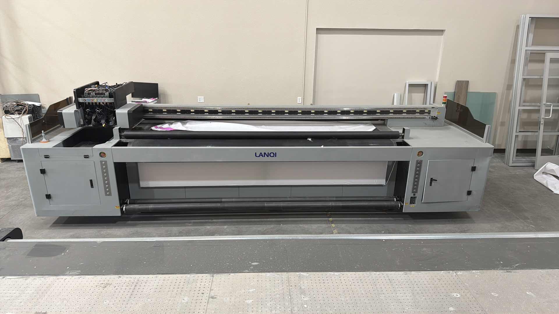 Photo 1 of LANOI INDUSTRIAL LARGE-FORMAT ROLL PRINTER, USED FOR HIGH-VOLUME COMMERCIAL PRINTING ON FLEXIBLE MATERIALS. TECHNOLOGY: USES UV INKJET PRINTING WITH INDUSTRIAL PRINTHEADS (SUCH AS RICOH GEN5/GEN6) FOR IMMEDIATE INK CURING AND DURABILITY. CAPACITY: ENGINEE
