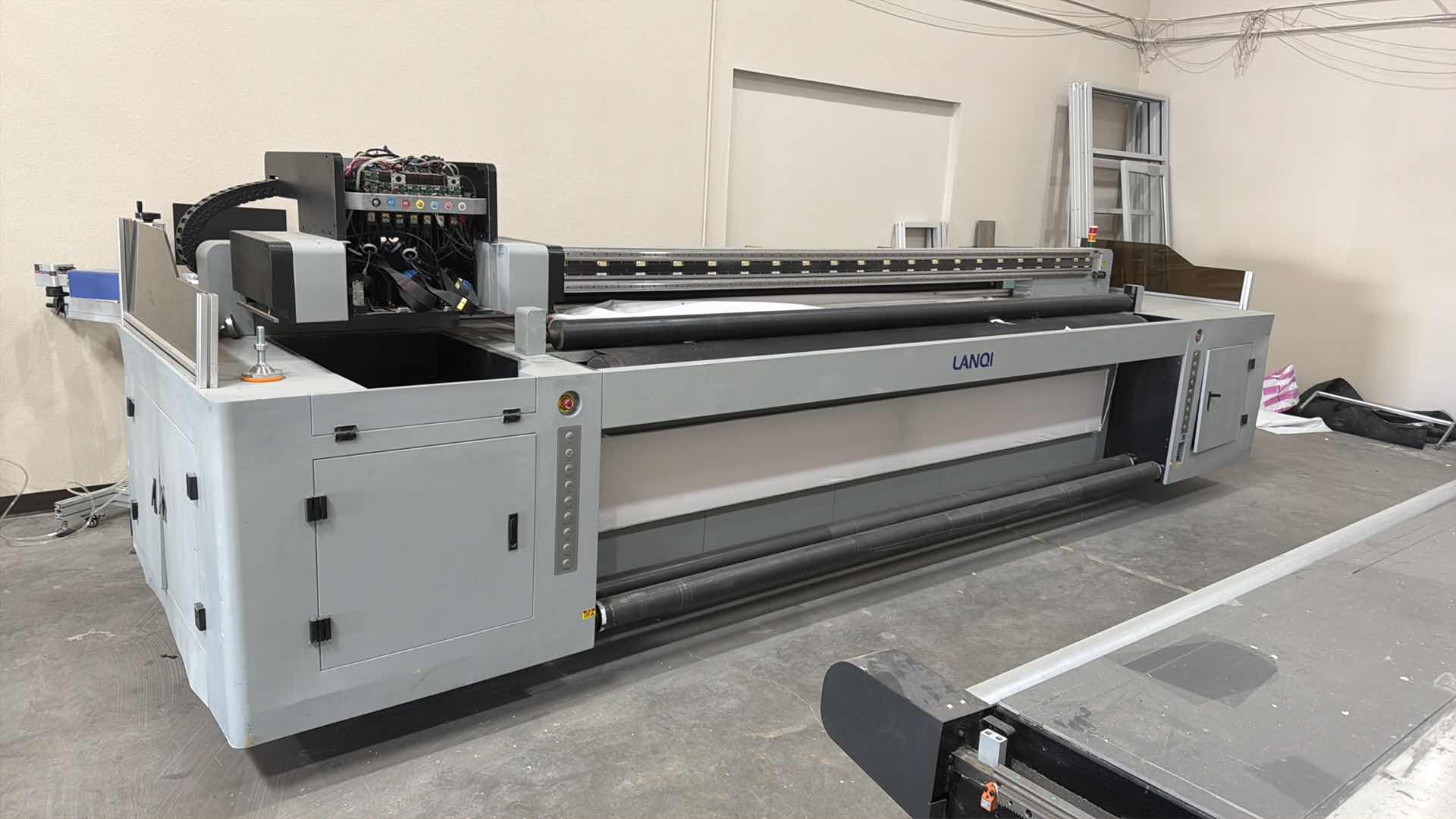 Photo 1 of LANOI INDUSTRIAL LARGE-FORMAT ROLL PRINTER, USED FOR HIGH-VOLUME COMMERCIAL PRINTING ON FLEXIBLE MATERIALS. TECHNOLOGY: USES UV INKJET PRINTING WITH INDUSTRIAL PRINTHEADS (SUCH AS RICOH GEN5/GEN6) FOR IMMEDIATE INK CURING AND DURABILITY. CAPACITY: ENGINEE