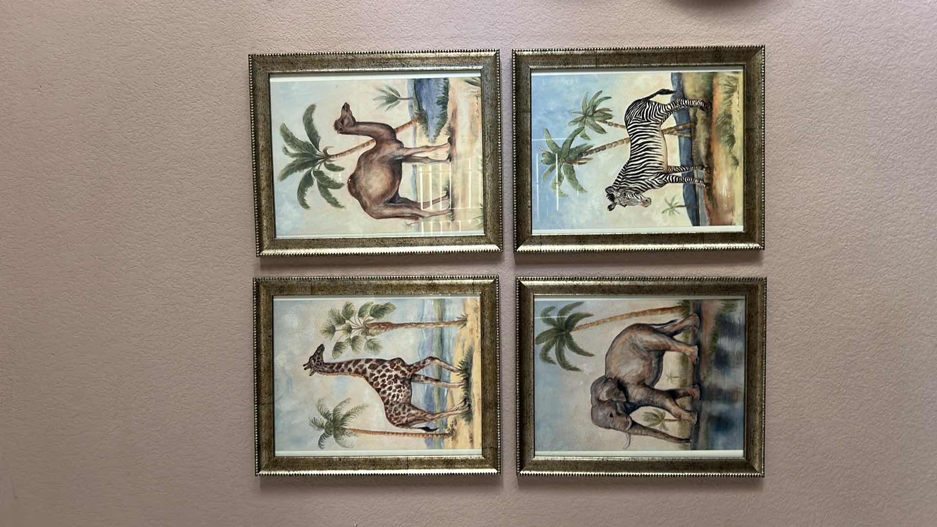 Photo 1 of SET A FOUR "ANIMALS AFRICANA" PRINT ARTWORK PIECES BY ALEXANDRA CHURCHILL, FEATURING A GIRAFFE, CAMEL, ELEPHANT AND ZEBRA IN RUSTIC GOLD FRAMES. 13” x H 16”