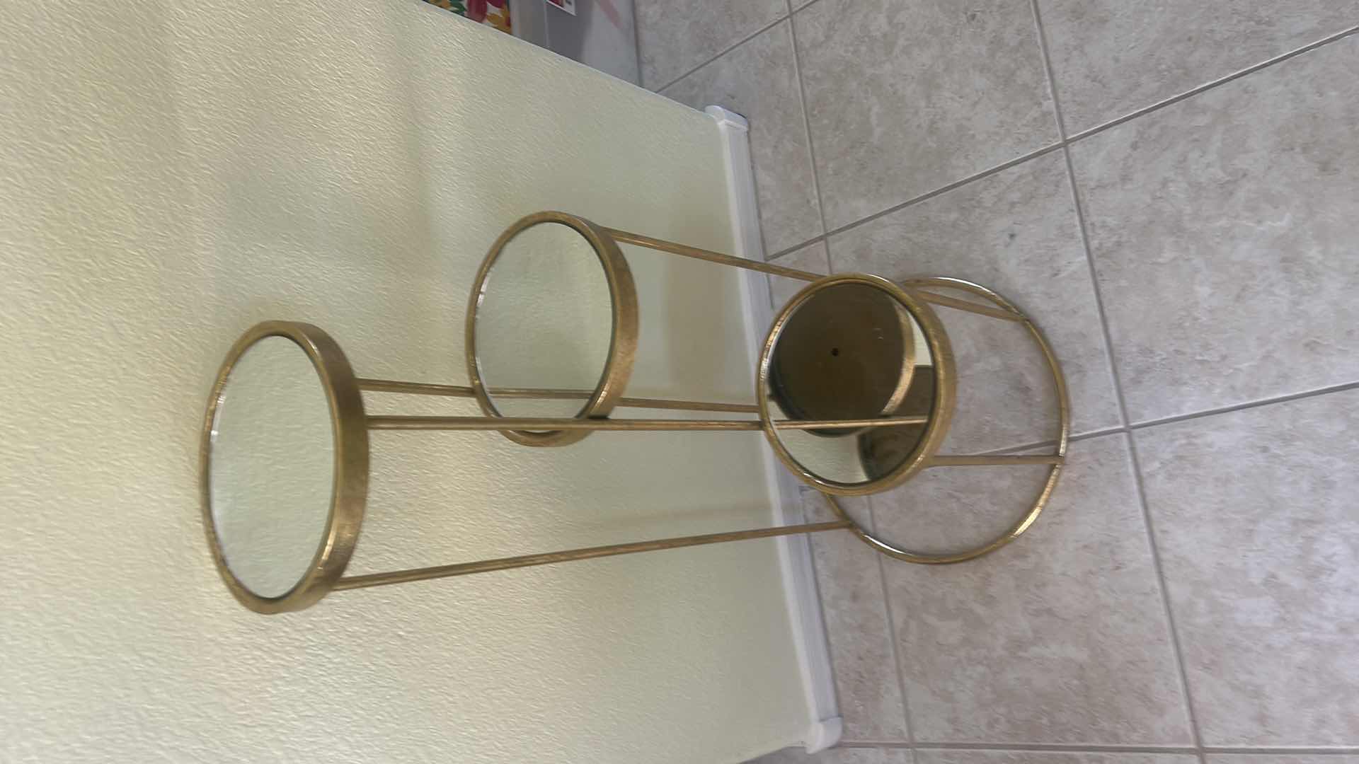 Photo 1 of GOLD METAL PLANT STAND FEATURING THREE ROUND MIRRORED DISPLAY SHELVES AT STAGGERED HEIGHTS 14” x H32”. $40