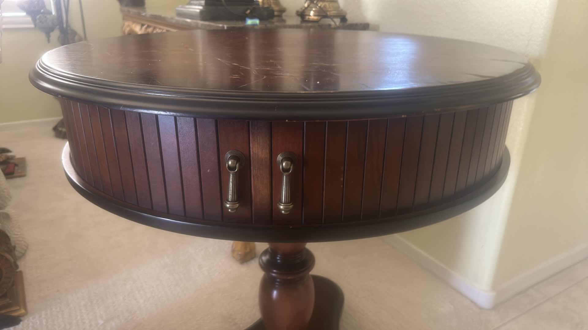 Photo 1 of BUTLER SPECIALTY COMPANY ELLSWORTH FOYER TABLE FEATURING A ROUND TOP, RIBBED CYLINDRICAL CABINET BASE, AND INTERIOR STORAGE COMPARTMENT. 29 1/4“ x 29 1/2“.