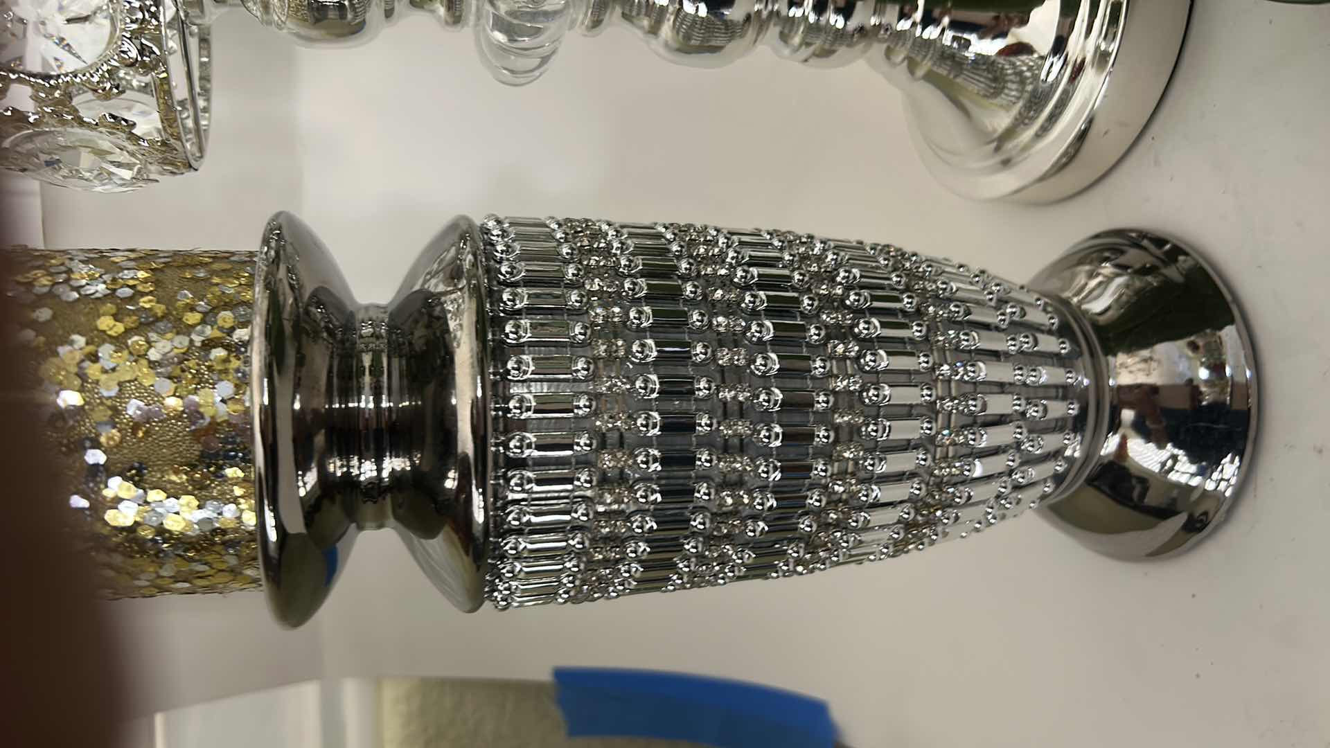 Photo 1 of THREE SILVER TONE CANDLE HOLDERS AND TWO DECORATIVE CANDLES. (TALLEST 16”)