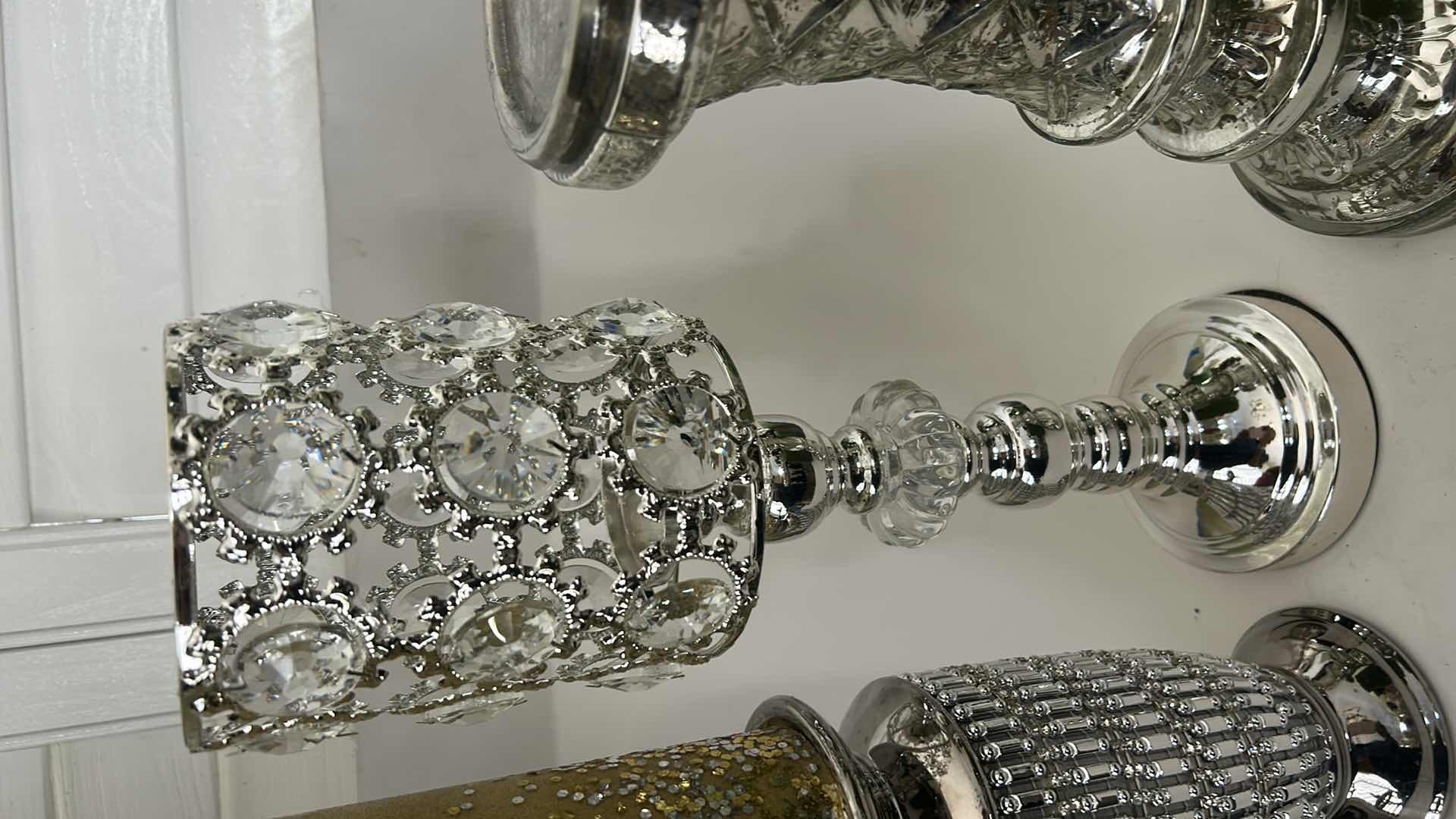 Photo 1 of THREE SILVER TONE CANDLE HOLDERS AND TWO DECORATIVE CANDLES. (TALLEST 16”)