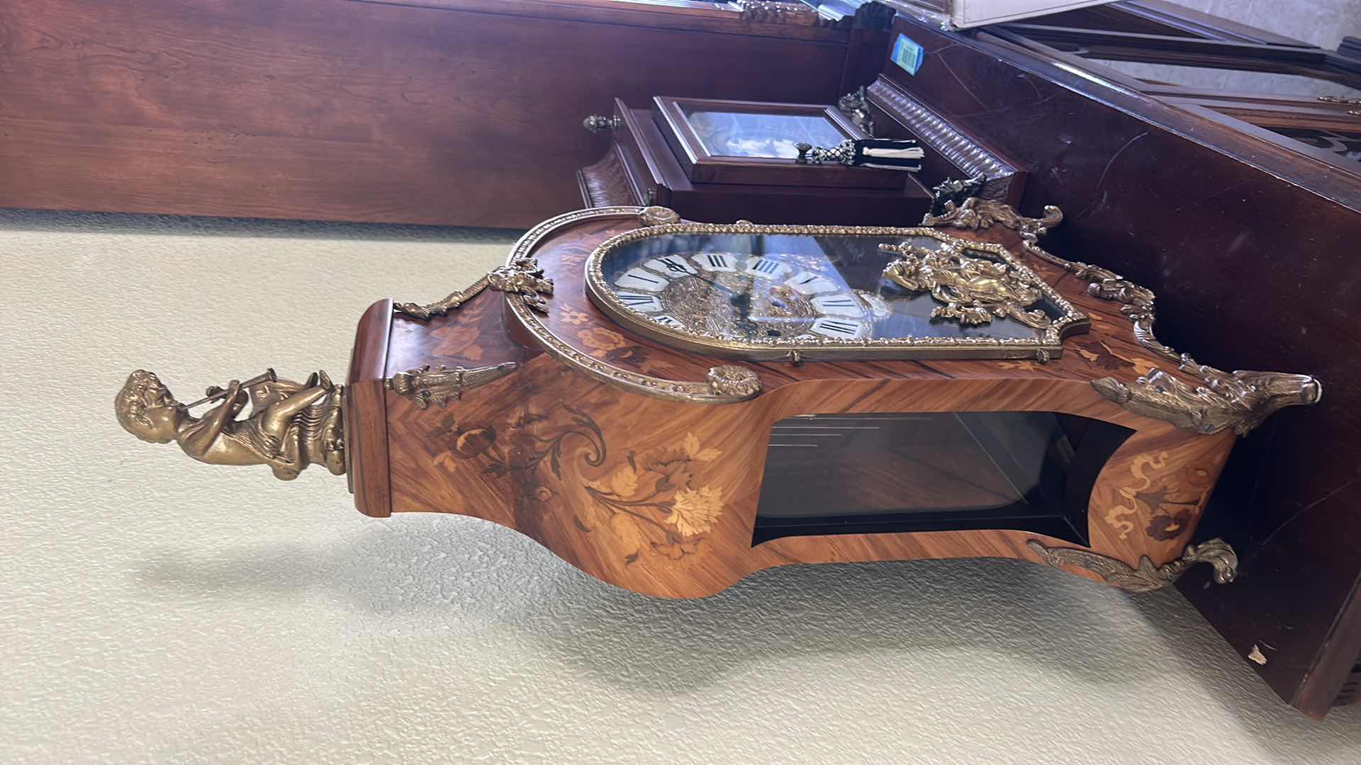 Photo 1 of TIFFANY MADE IN ITALY - FRENCH STYLE VERSAILLES CLOCK FEATURES AN ORNATE GILDED METAL CASE WITH ELABORATE SCROLLWORK, FLORAL MOTIFS, AND A DECORATIVE FINIAL. MATCHING PEDESTAL 14 1/2“ x 6 1/4“ x H31“ PEDESTAL16 1/2” x 9 1/2” x H 44 1/2” TOTAL HEIGHT, INCL