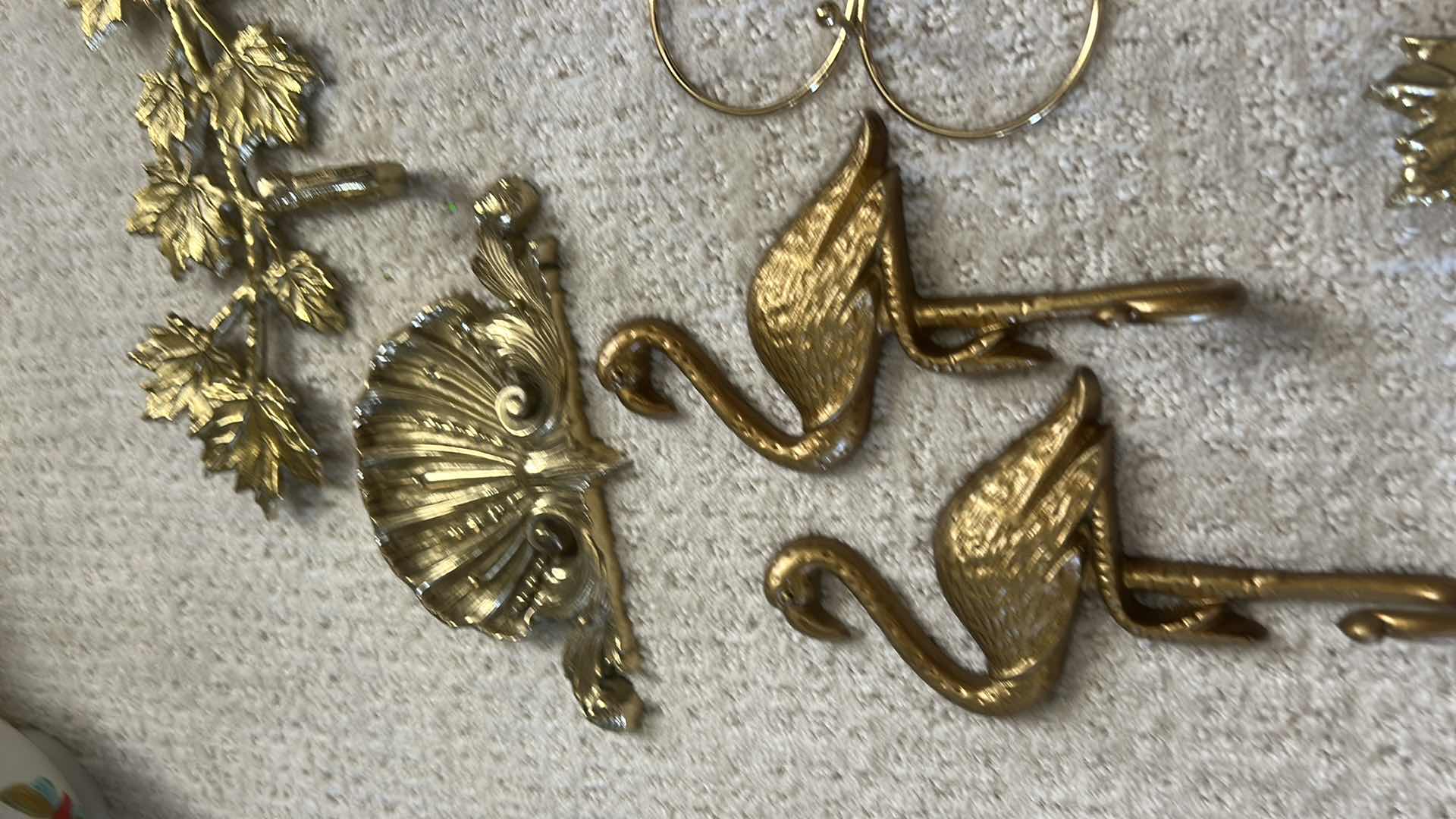 Photo 1 of GOLD-COLORED METAL WALL RACKS FEATURING HOOKS FOR ORGANIZING ITEMS.