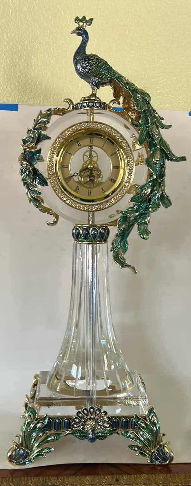 Photo 1 of REGIS GALERIE PEACOCK CRYSTAL CLOCK FEATURES AN ORNATE, ENAMELED PEACOCK FIGURE PERCHED ATOP A CLEAR CRYSTAL STAND H 24”