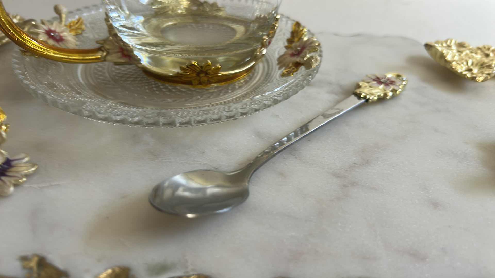 Photo 1 of VINTAGE-STYLE ENAMEL GLASS FLORAL TEA CUP FEATURES INTRICATE 3D BUTTERFLY AND ROSE DETAILS ON THE HANDLE AND LID & HANDMADE SERVING TRAY FEATURES A WHITE MARBLE BASE ACCENTED WITH INTRICATE GOLD-FINISHED METAL HANDLES.
